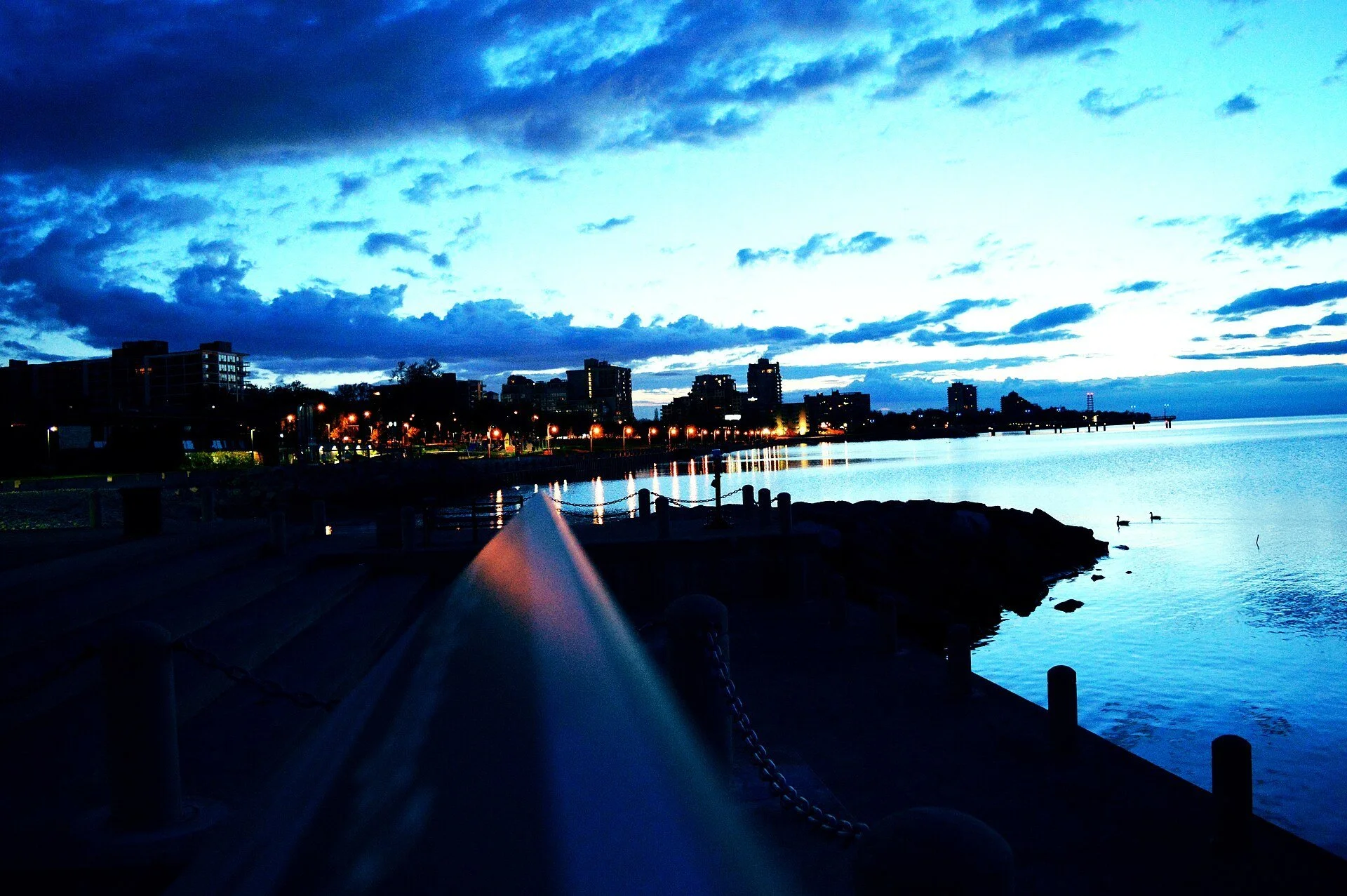 The Spencer Smith Park waterfront and downtown Burlington lights reflected in Lake Ontario at dawn.