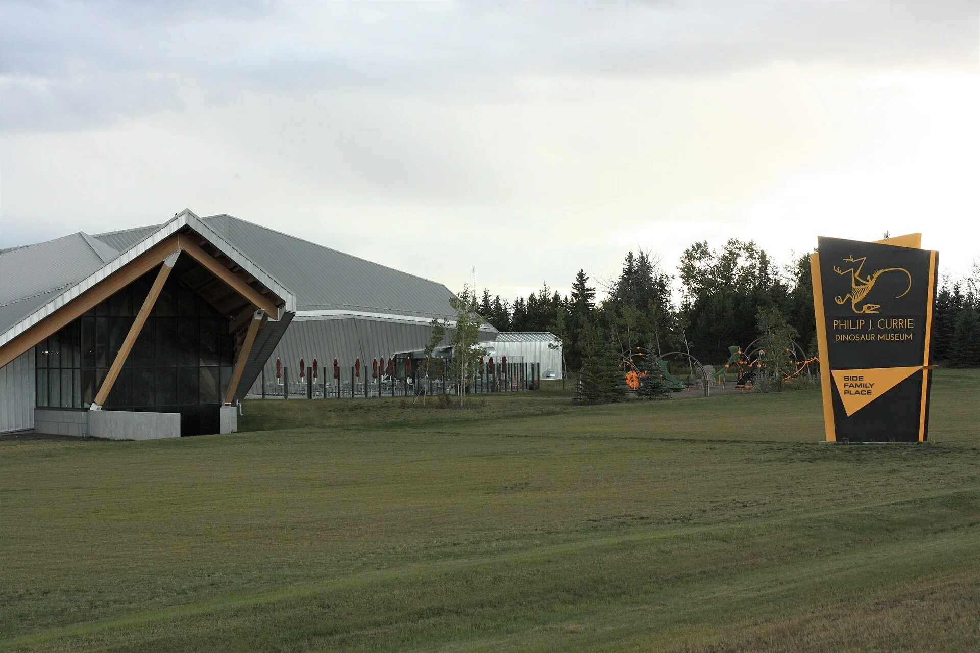 The angular roofline and entrance sign of the Philip J. Currie Dinosaur Museum near Wembley, west of Grande Prairie.