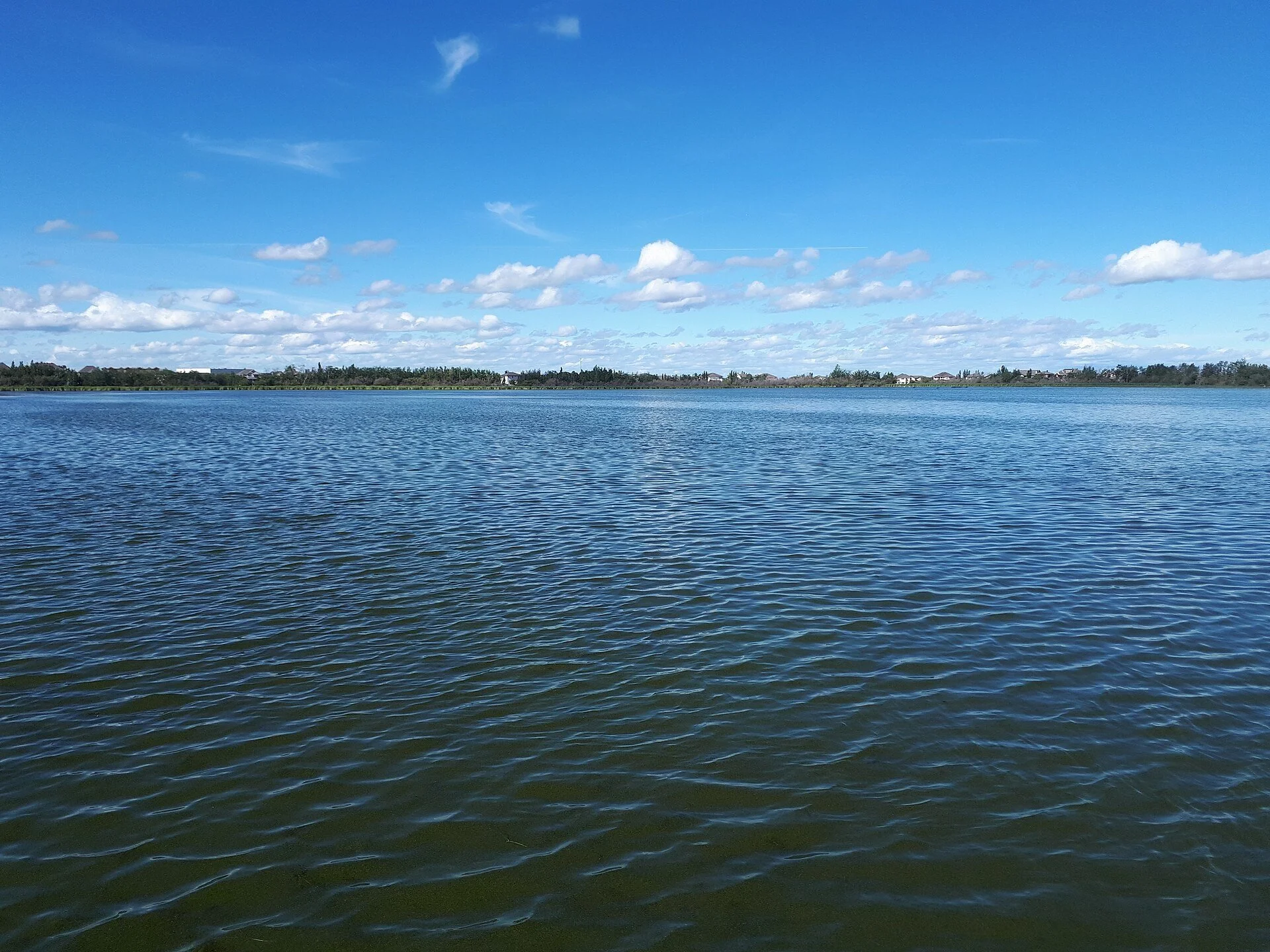 Blue water under a clear sky at Crystal Lake in Grande Prairie, Alberta.