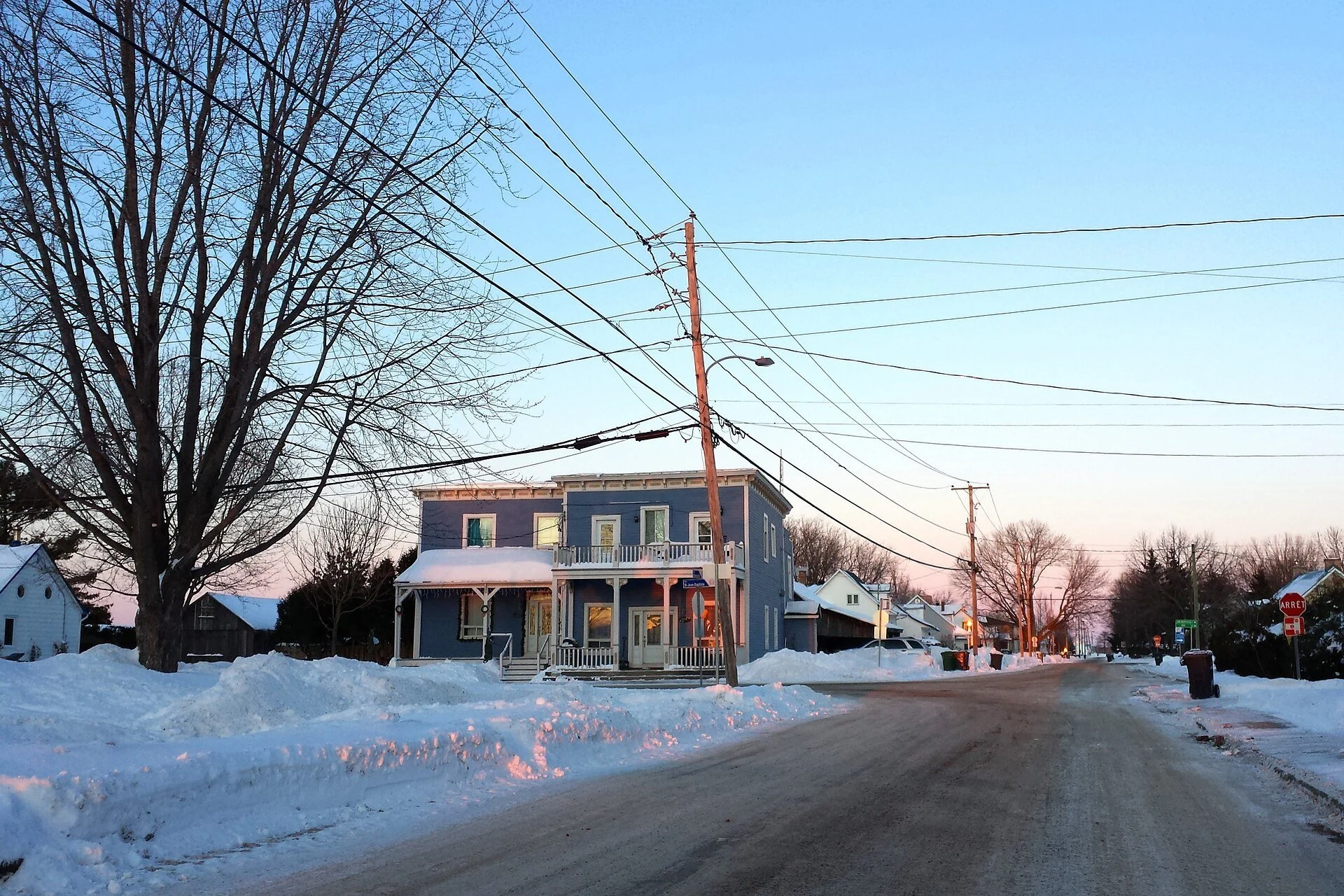 A snowy main street with old houses in the village of Saint-Benoît in Mirabel, Quebec.