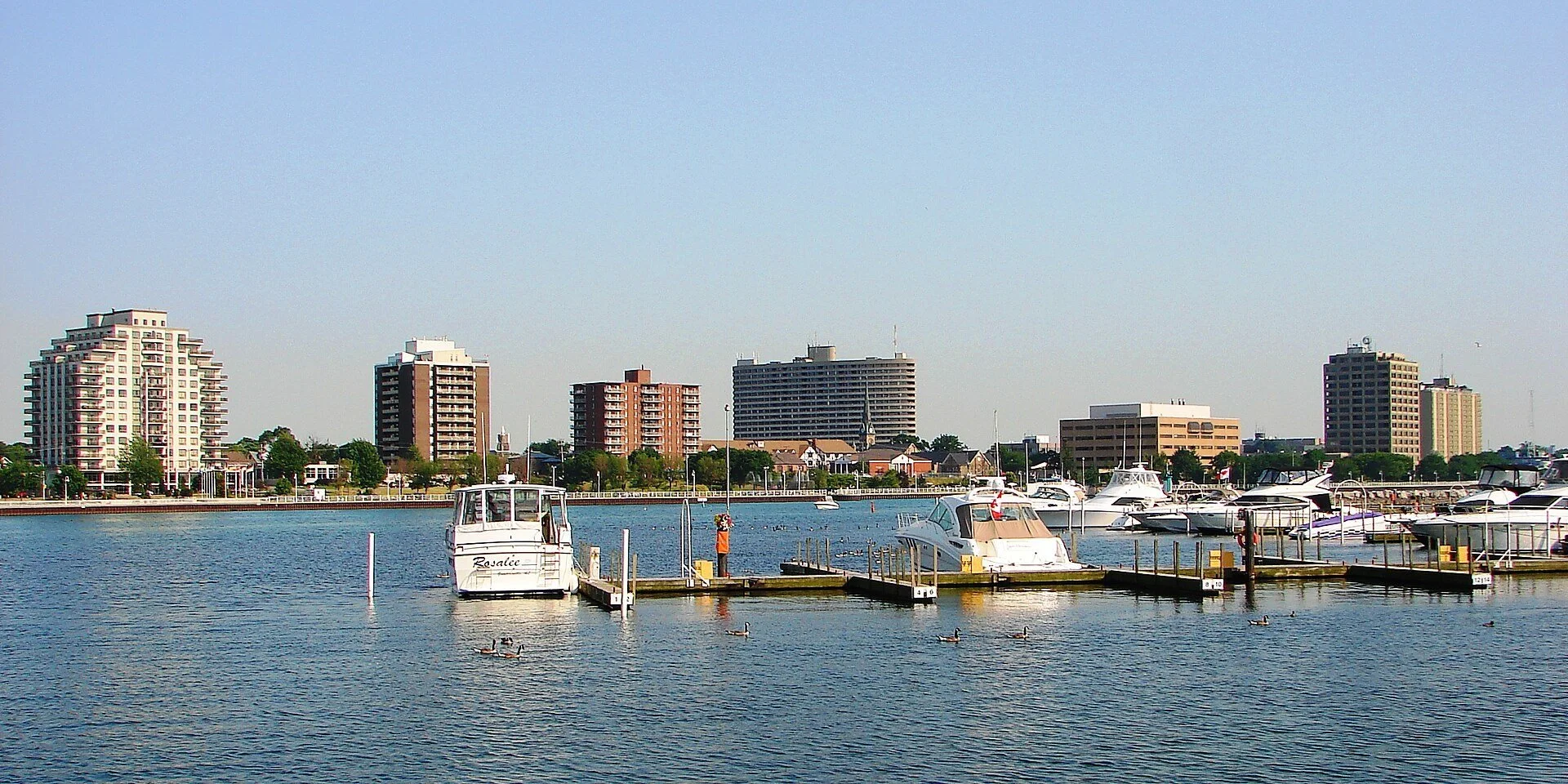 Boats moored at a marina on Sarnia Bay with the downtown Sarnia, Ontario skyline behind.