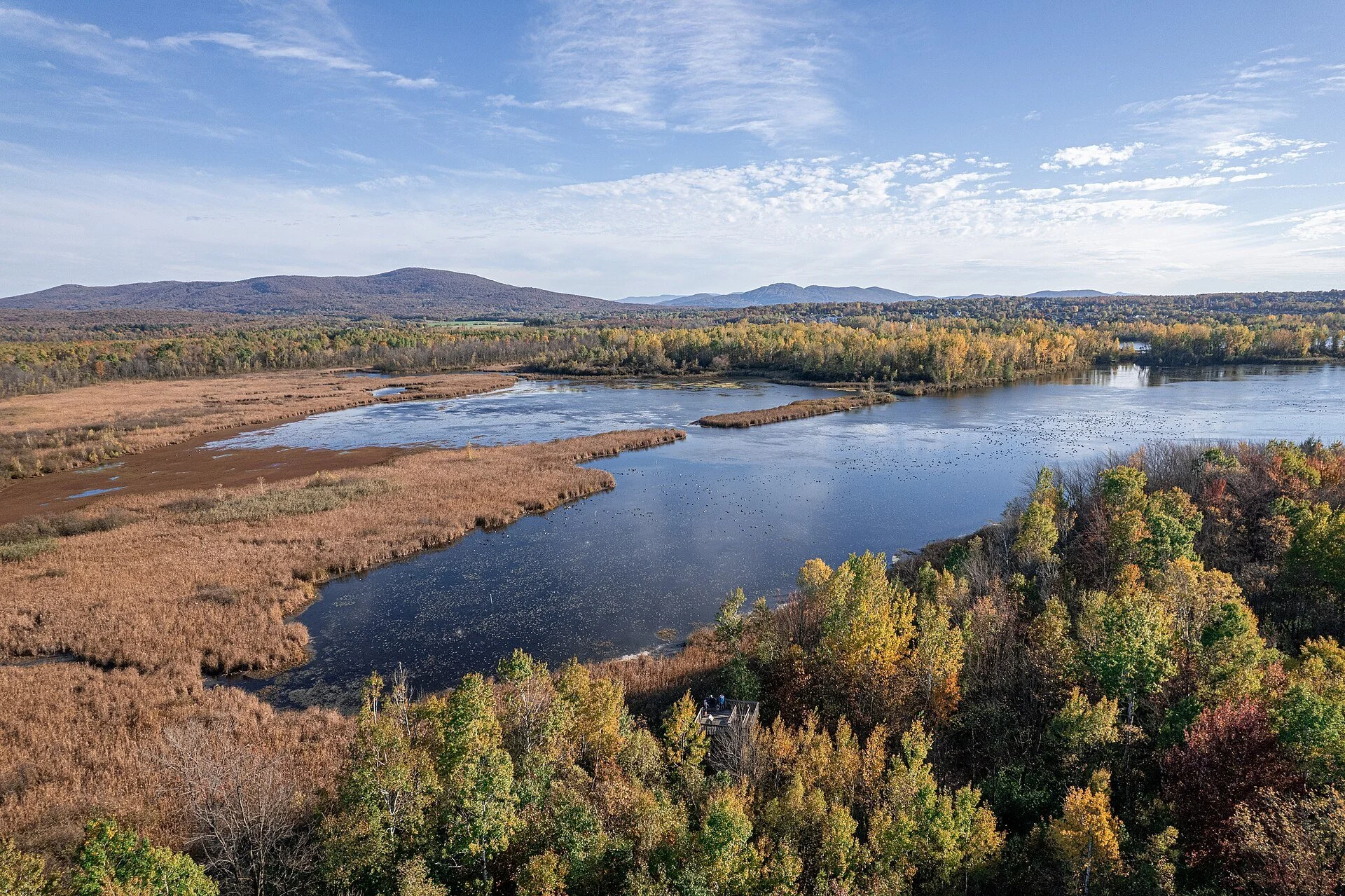 Lac Boivin and its marshes in autumn colour, with the Monts Shefford in the distance, in Granby, Quebec.