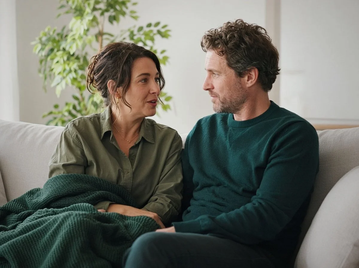 Couple sitting on a couch having a calm, honest conversation