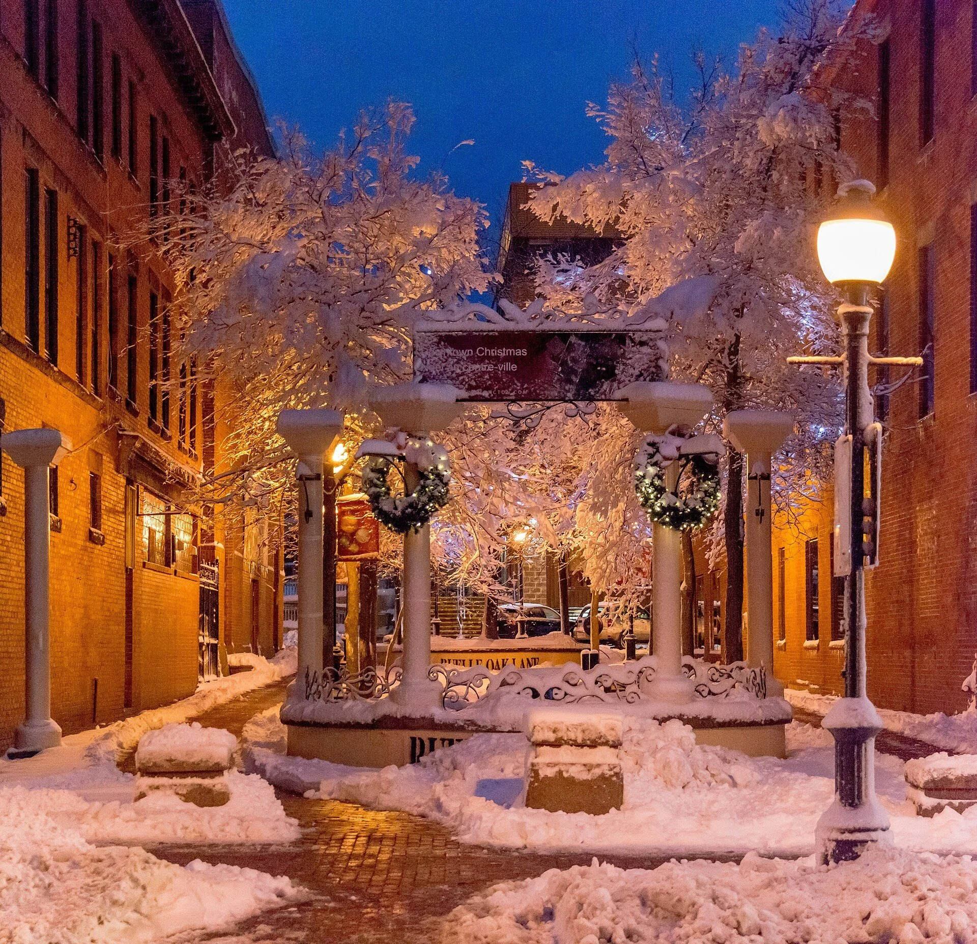 A lit street lamp and a snow-covered pedestrian lane after the first snowfall in downtown Moncton.
