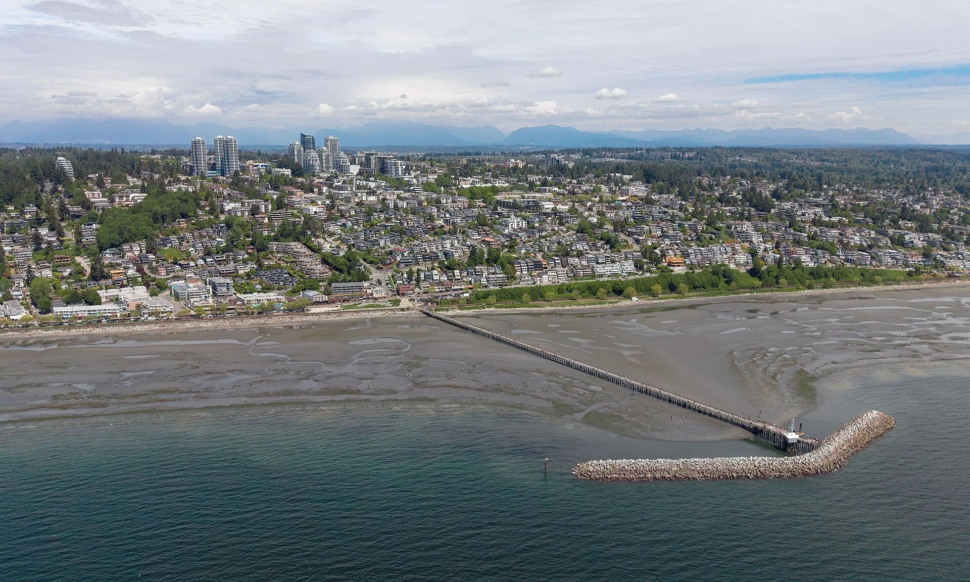 Aerial view of White Rock, British Columbia, with the pier reaching across the tidal flats of Semiahmoo Bay.