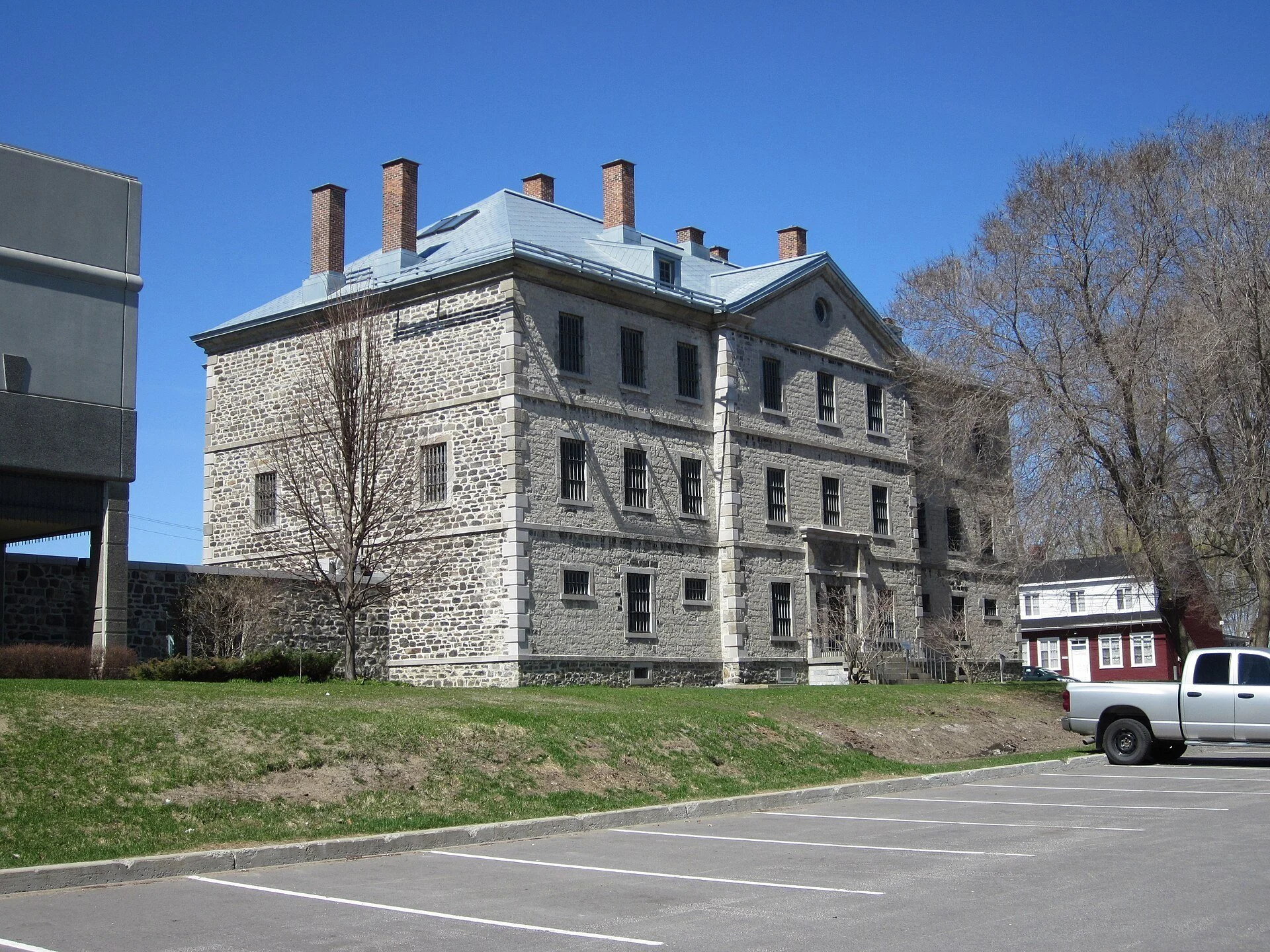 The grey stone Vieille prison of Trois-Rivières under a blue sky.
