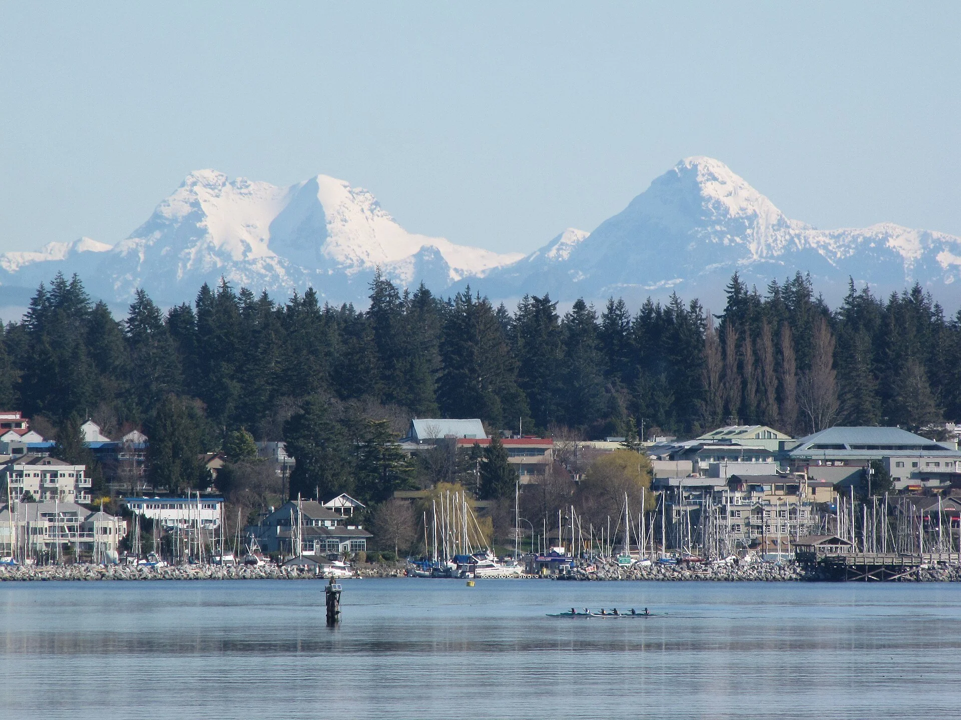 Comox waterfront and marina with snowy mountains behind.