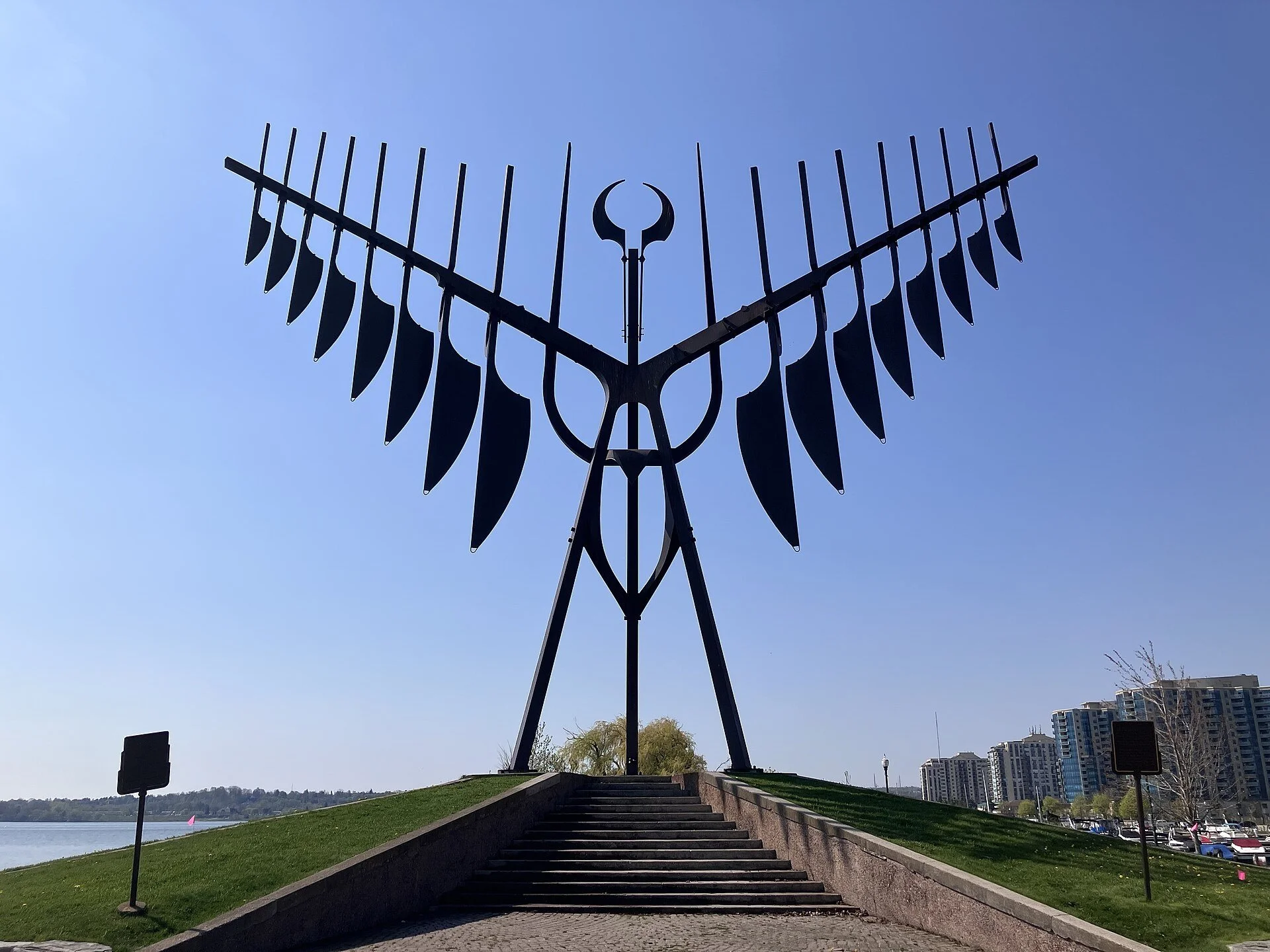 The tall steel Spirit Catcher sculpture with its outspread quills on the Barrie waterfront against a blue sky.