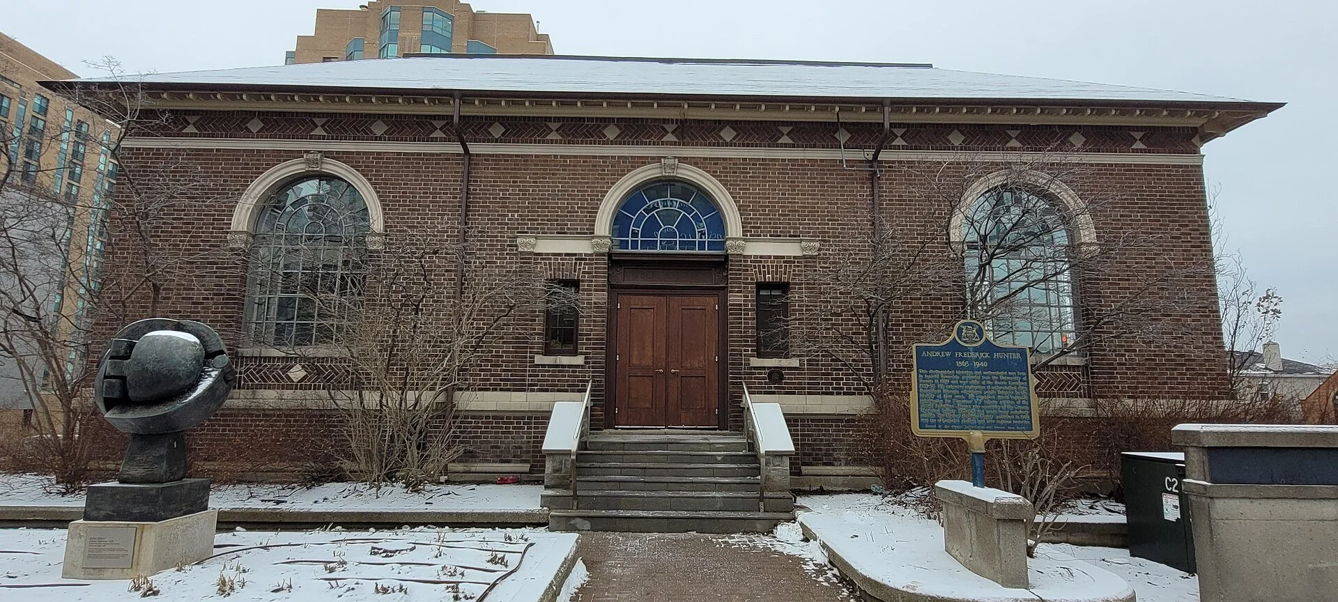 The red brick former Carnegie library building of the MacLaren Art Centre in downtown Barrie, with snow on the ground.