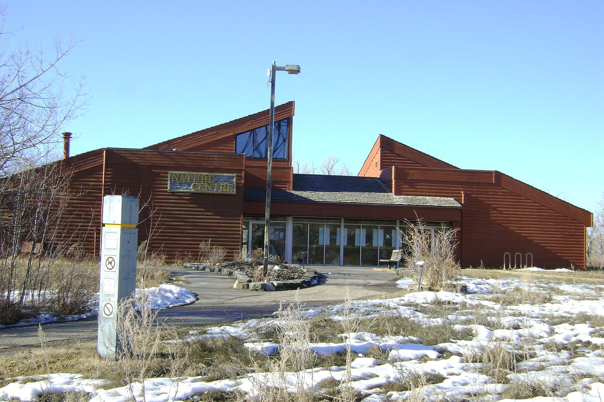 The Helen Schuler Nature Centre building with patches of snow in the river valley.