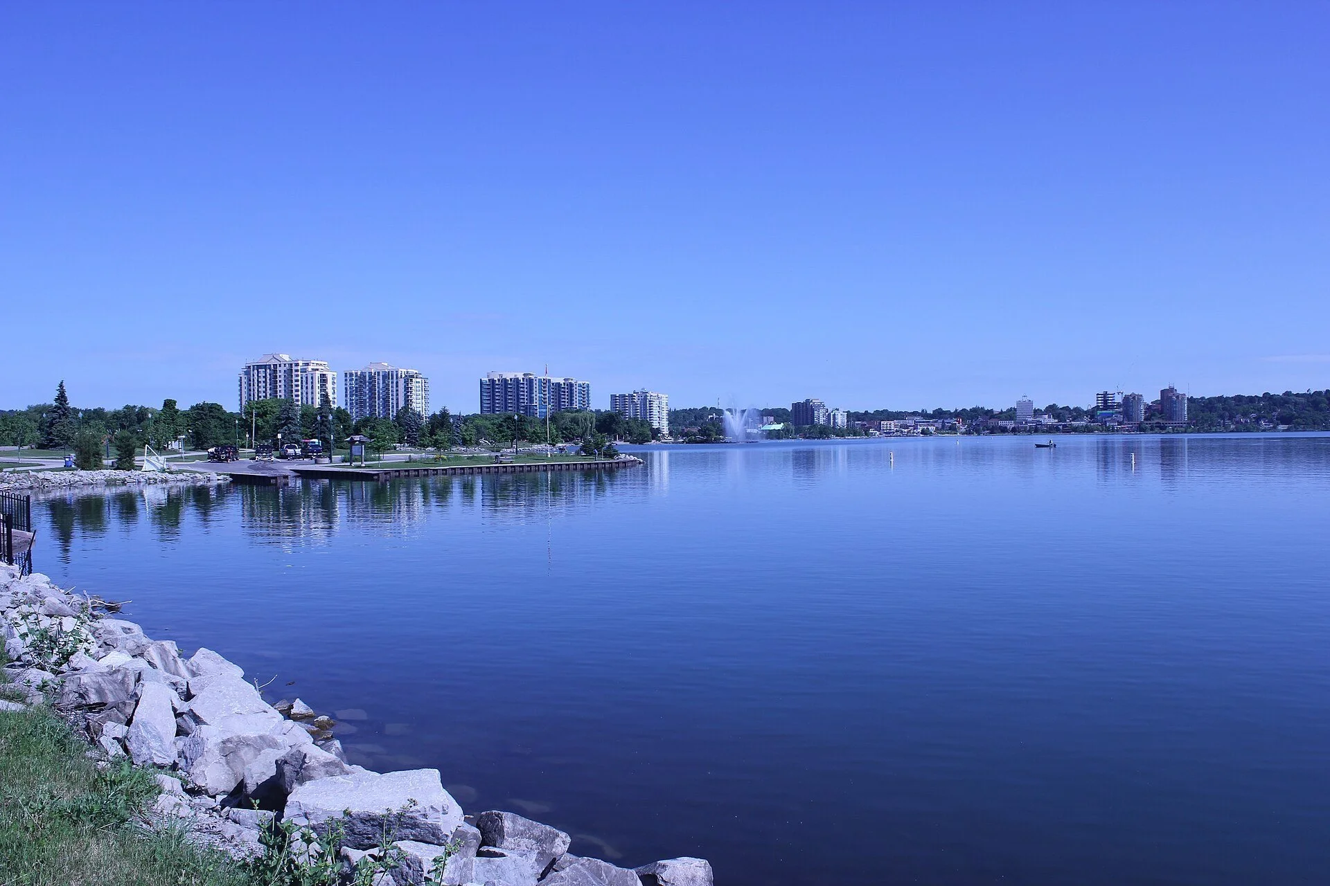 Calm blue water of Kempenfelt Bay with the Barrie waterfront and downtown towers along the far shore.