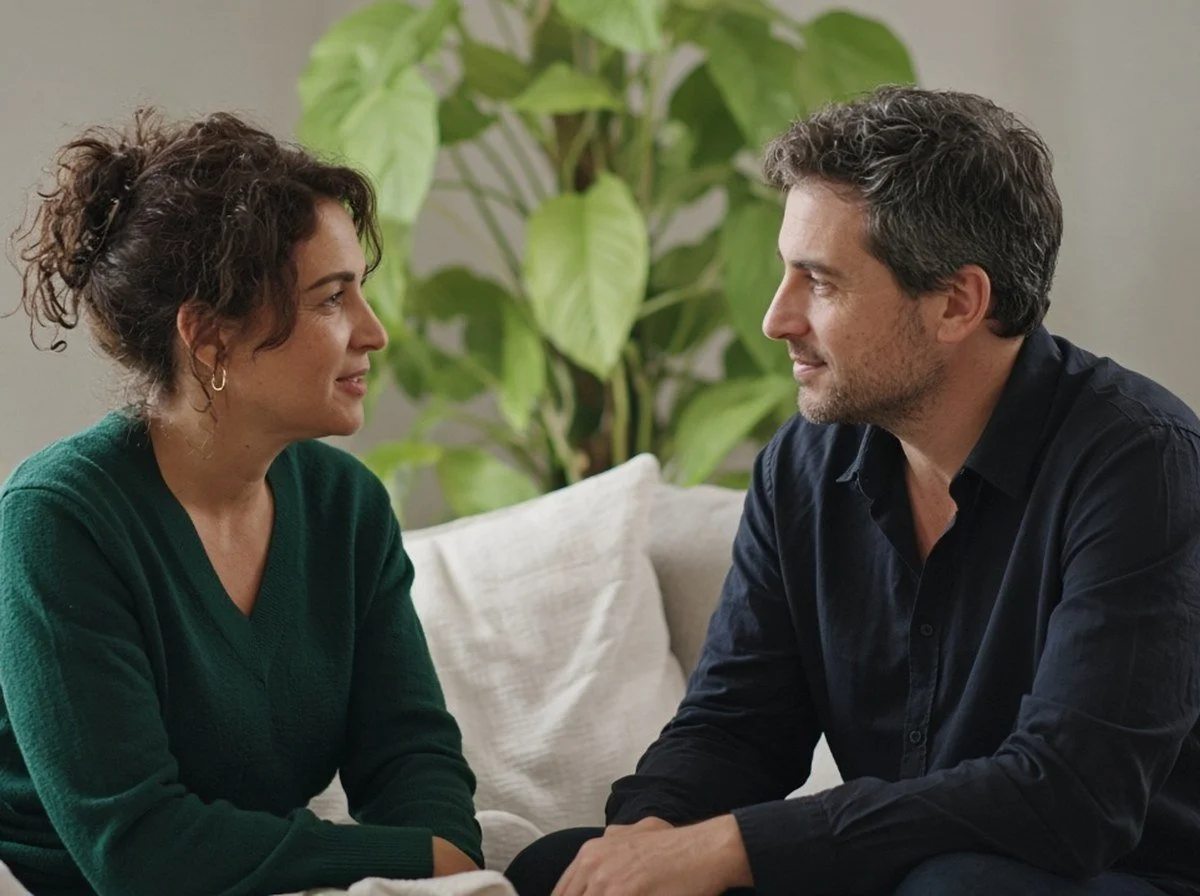 Two adults sitting face to face, both faces visible, talking gently