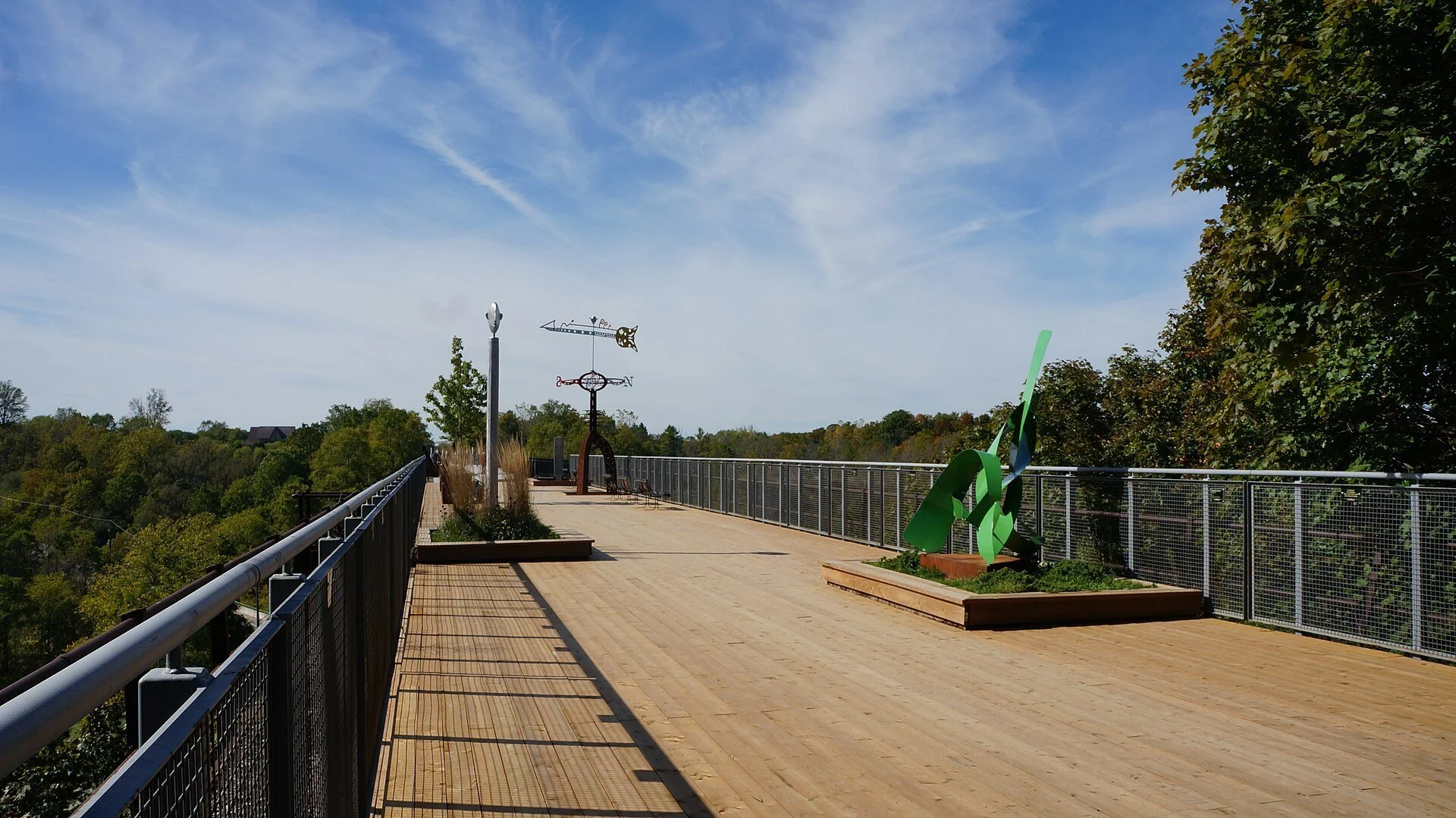 The walkway of the St. Thomas Elevated Park on the old rail bridge, lined with public art sculptures.