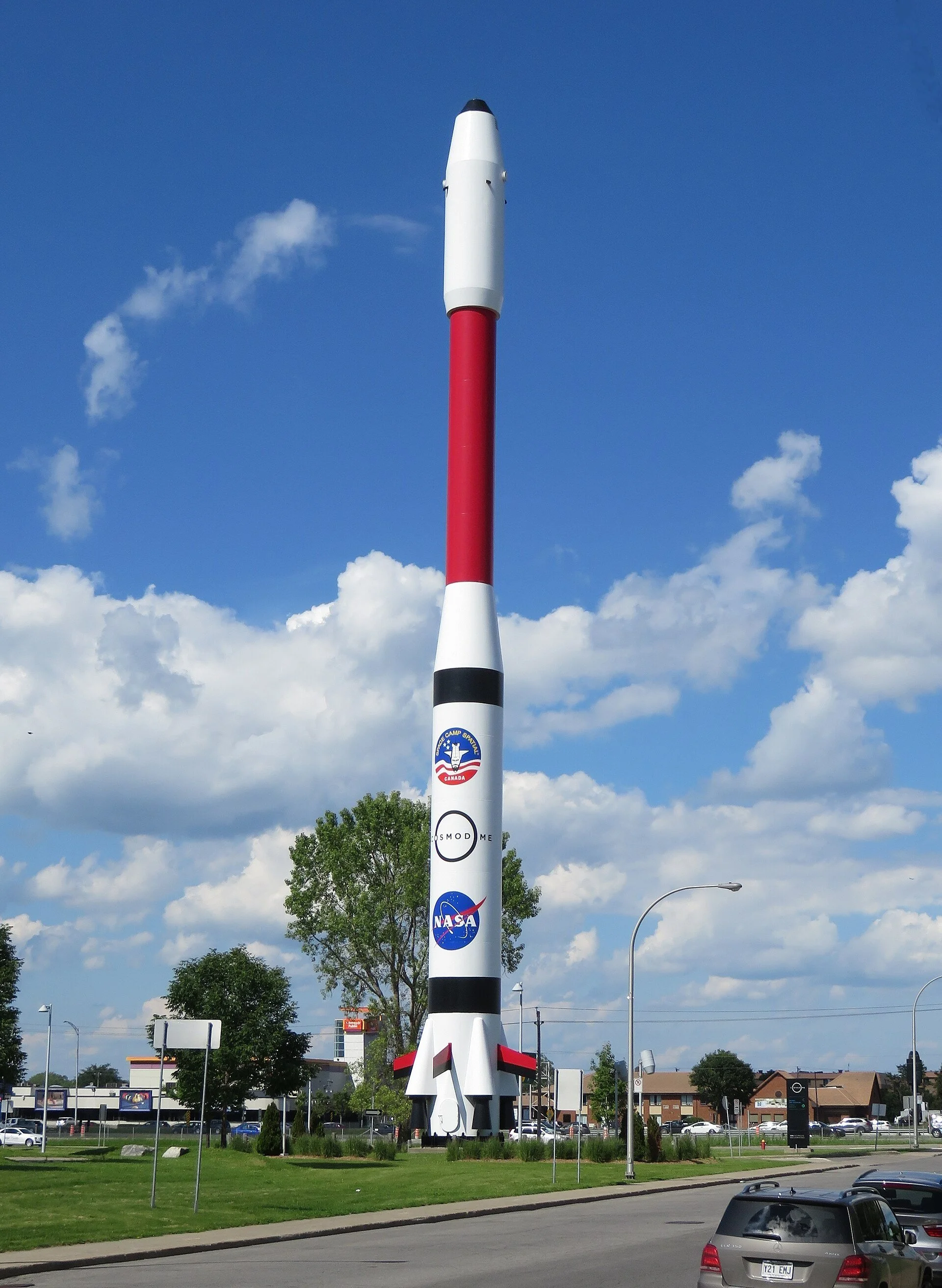 The tall red and white rocket outside the Cosmodome in Laval.