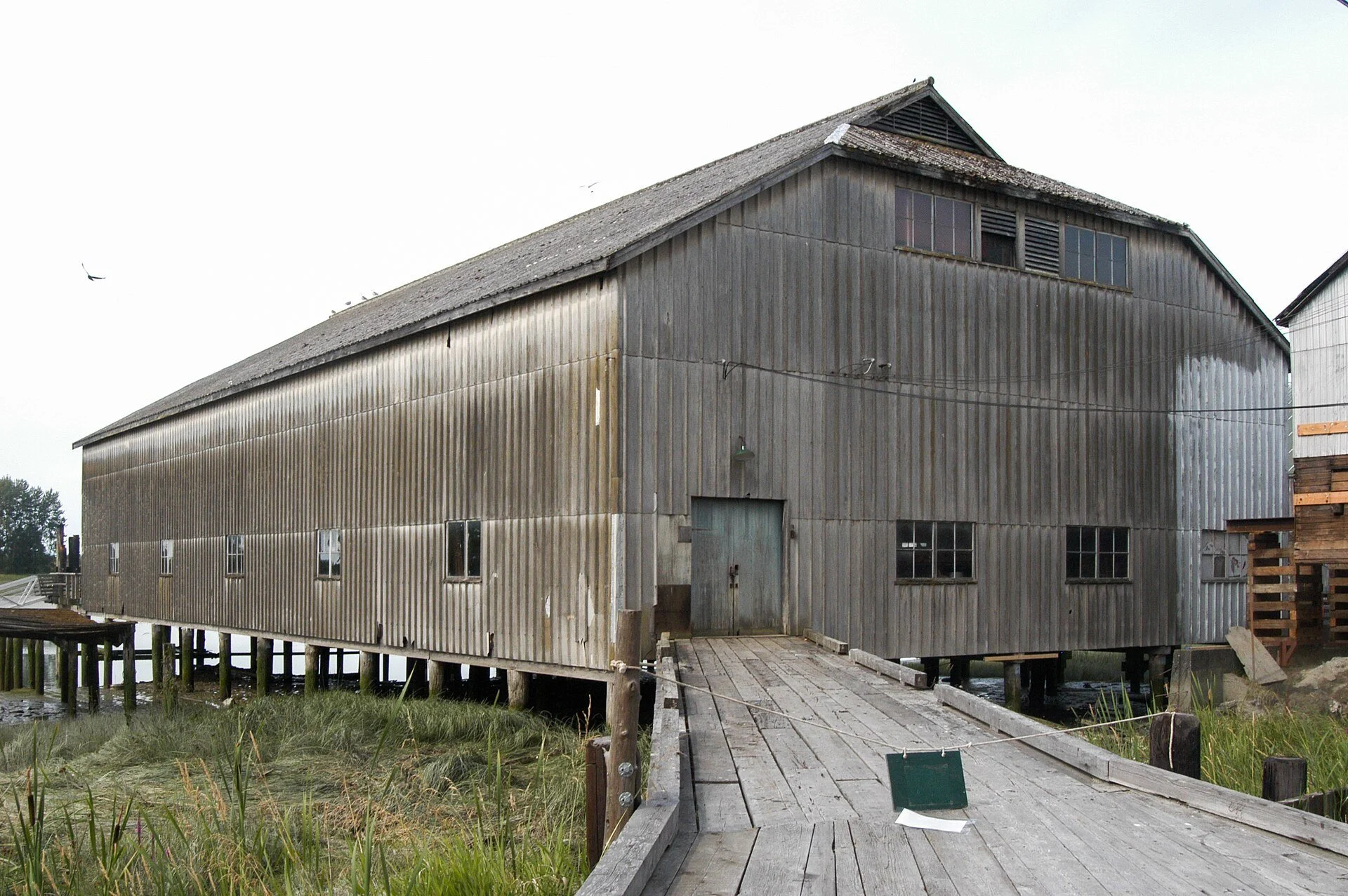 A heritage shipyard building and boardwalk at Britannia Shipyards in Richmond, BC.