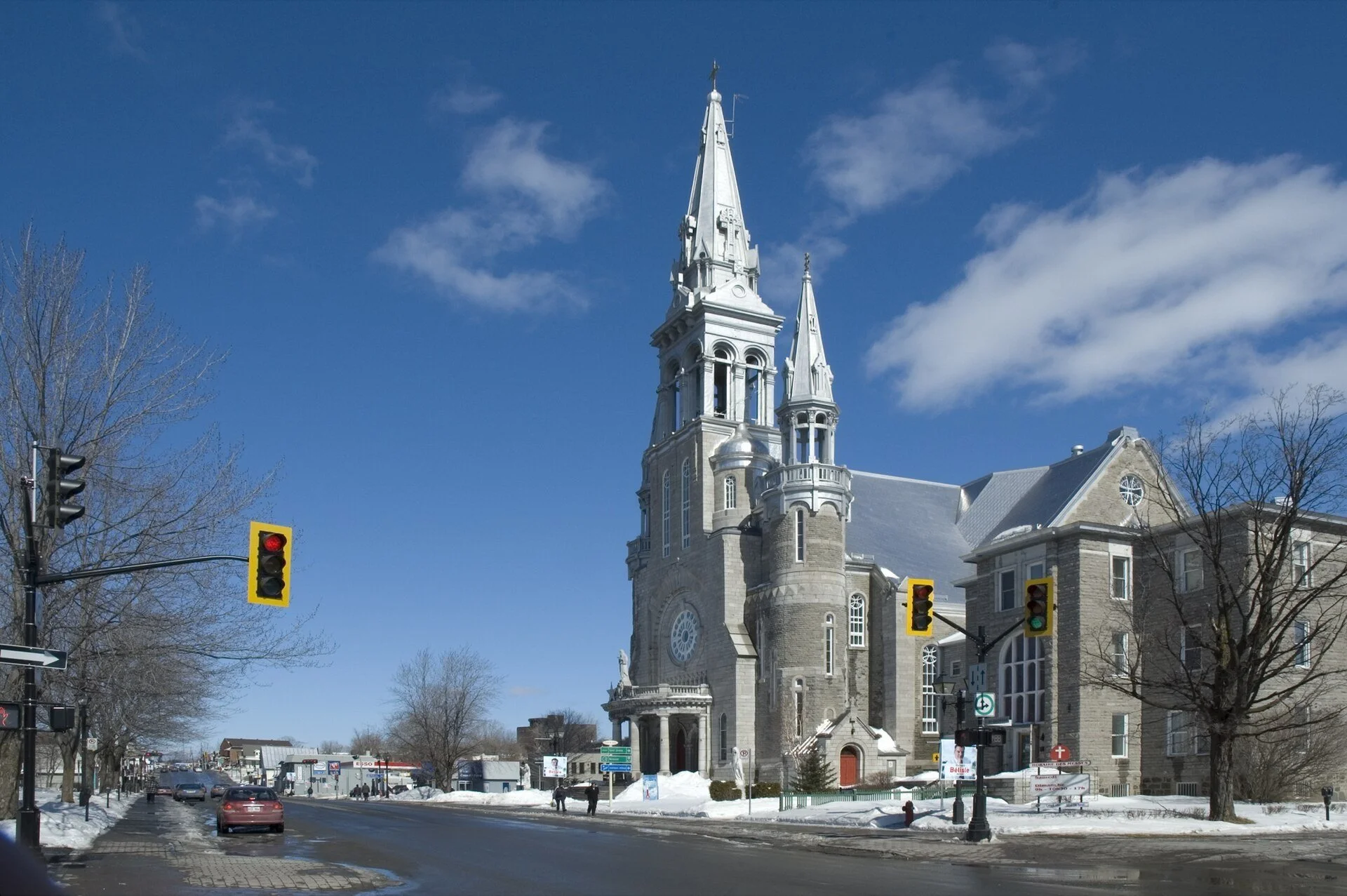 The grey stone cathedral of Saint-Jérôme, Quebec, with its tall twin spires under a blue sky.