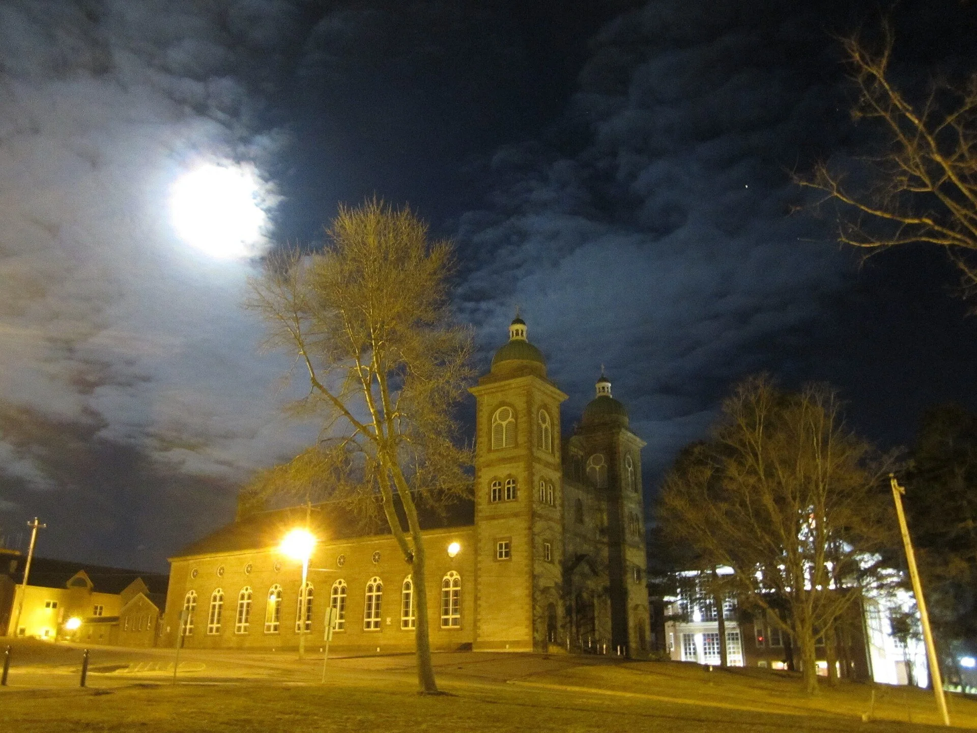 A landmark stone building on Main Street in Antigonish, lit at night.