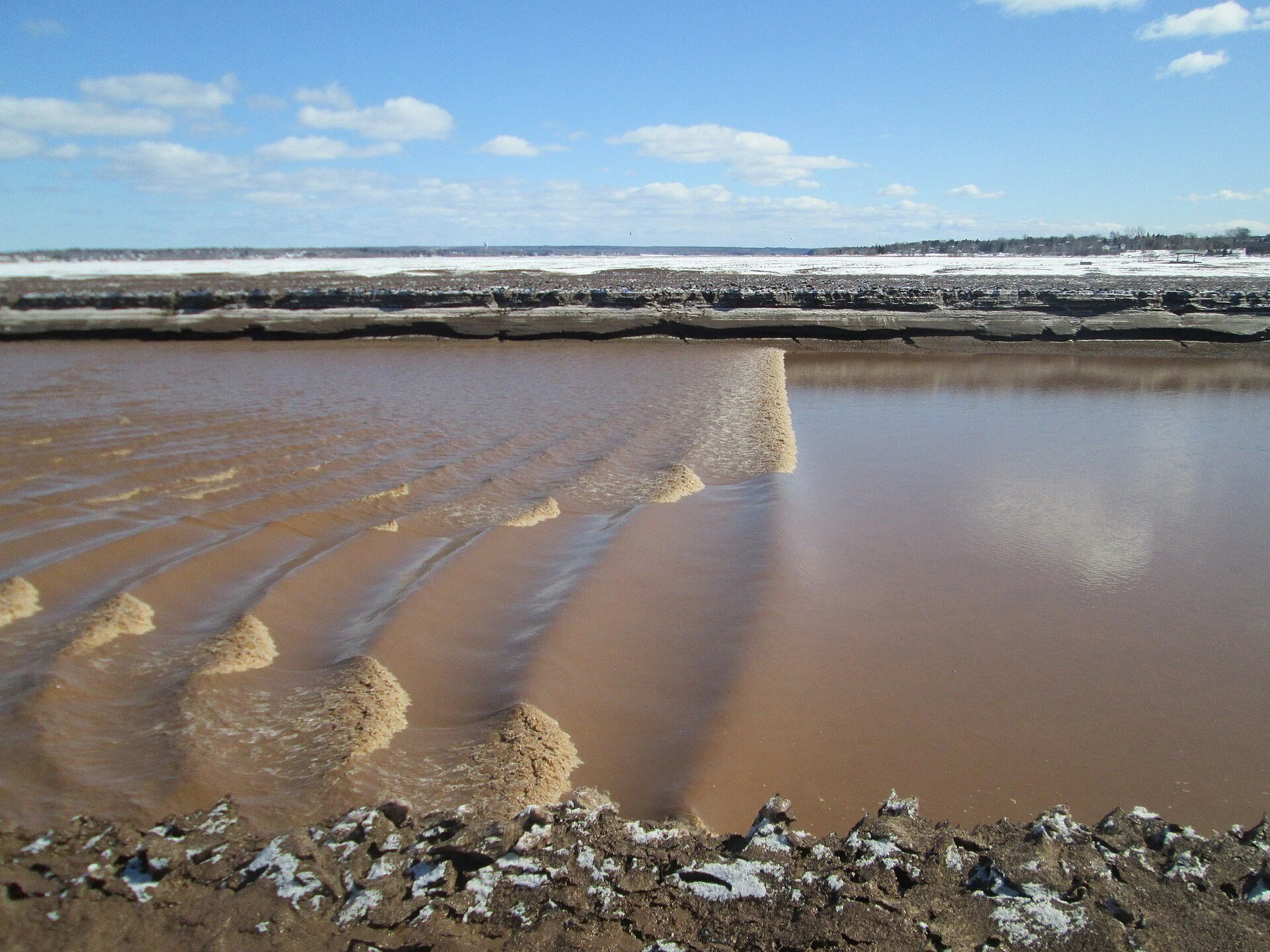 The tidal bore rolling up the muddy Petitcodiac River in Moncton, New Brunswick.
