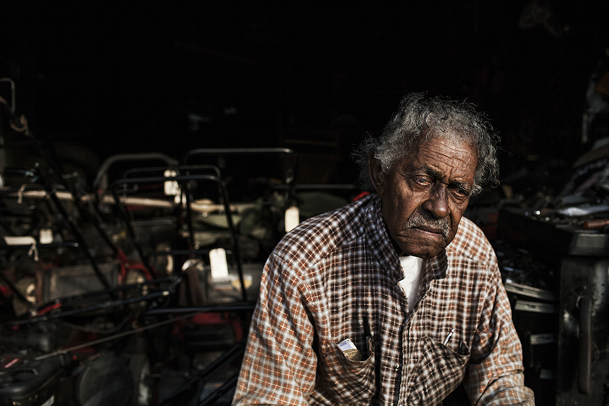 John Daye peers out from his garage where he repairs lawnmowers in Durham, N.C., on August 24, 2014. Daye has been repairing and selling lawnmowers for 21 years since his retirement as an engineer in the tobacco industry. Durham is home to the American Tobacco Company started by J.B. Duke in 1890 that soon became one of the 12 original members of the Dow Jones Industrial Average. The company left Durham in the late 1980’s leaving 1,000 people without jobs.