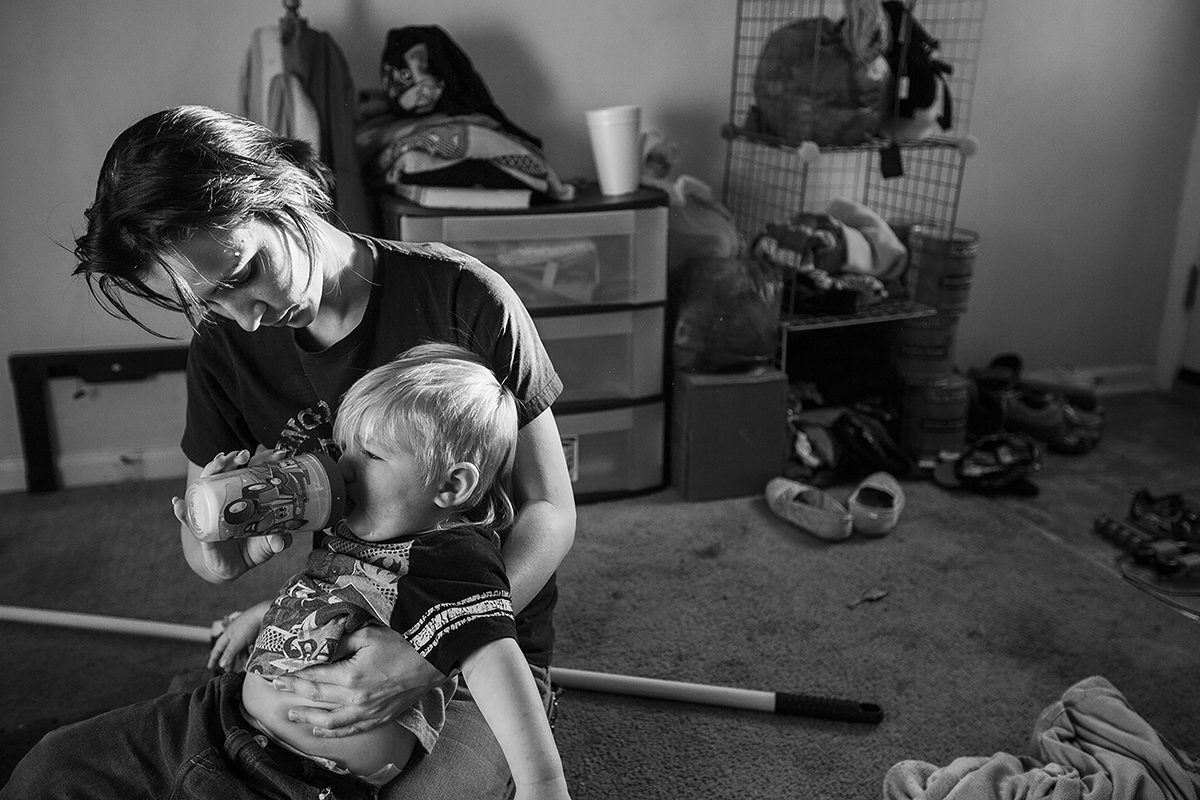 Arielle Morgan comforts her son Dominique, 2, with a sippy cup after he fell while playing in the living room in Durham, N.C. on October 15, 2015. Morgan lives with her mother as they both raise there two eight year old daughters and her son together as single mothers. According to the U.S. Census Bureau, one in four children under the age of 18 are being raised without a father and nearly half (45%) live below the poverty line. Arielle says that it would have been impossible for her to take on the responsibility of raising her daughter on her own at age 16, especially because of her daughters medical bills. Both mothers believe that staying together and raising their children together has transformed their relationship from mother-daughter to roommates and allowed them to handle the financial burdens of being single parents.