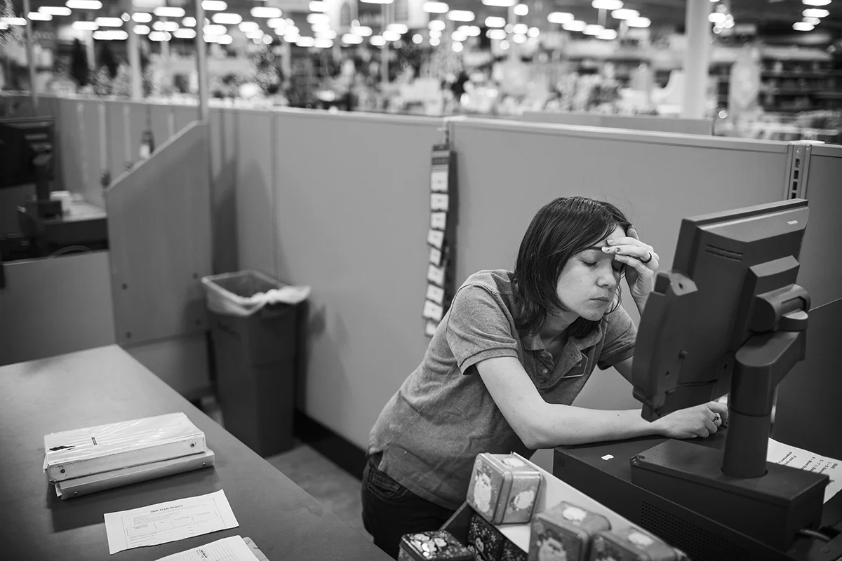  Arielle rests her head as shemcounts down the last few minutes before getting off work from a late shift at the At Home store in Durham, N.C.. Arielle recently had to pick up a third job in order to support her children. 