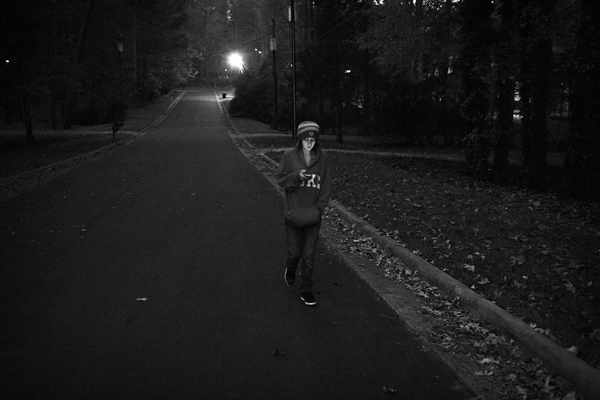  Arielle checks her social media accounts on her phone while walking to work at the Healthy Home Market. Because the family shares a vehicle and Arque takes the daughters to school, Arielle is forced to leave her house at 6am and walk two miles to wo