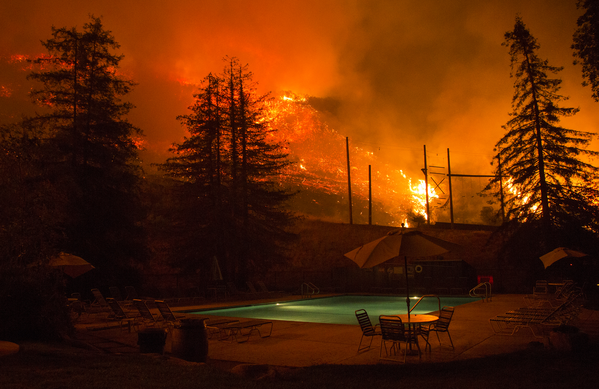  Flames approach a pool in the El Capitan Canyon camp as firefighters battle the Refugio fire in Santa Barbara, CA on Thursday, June 16, 2016. 