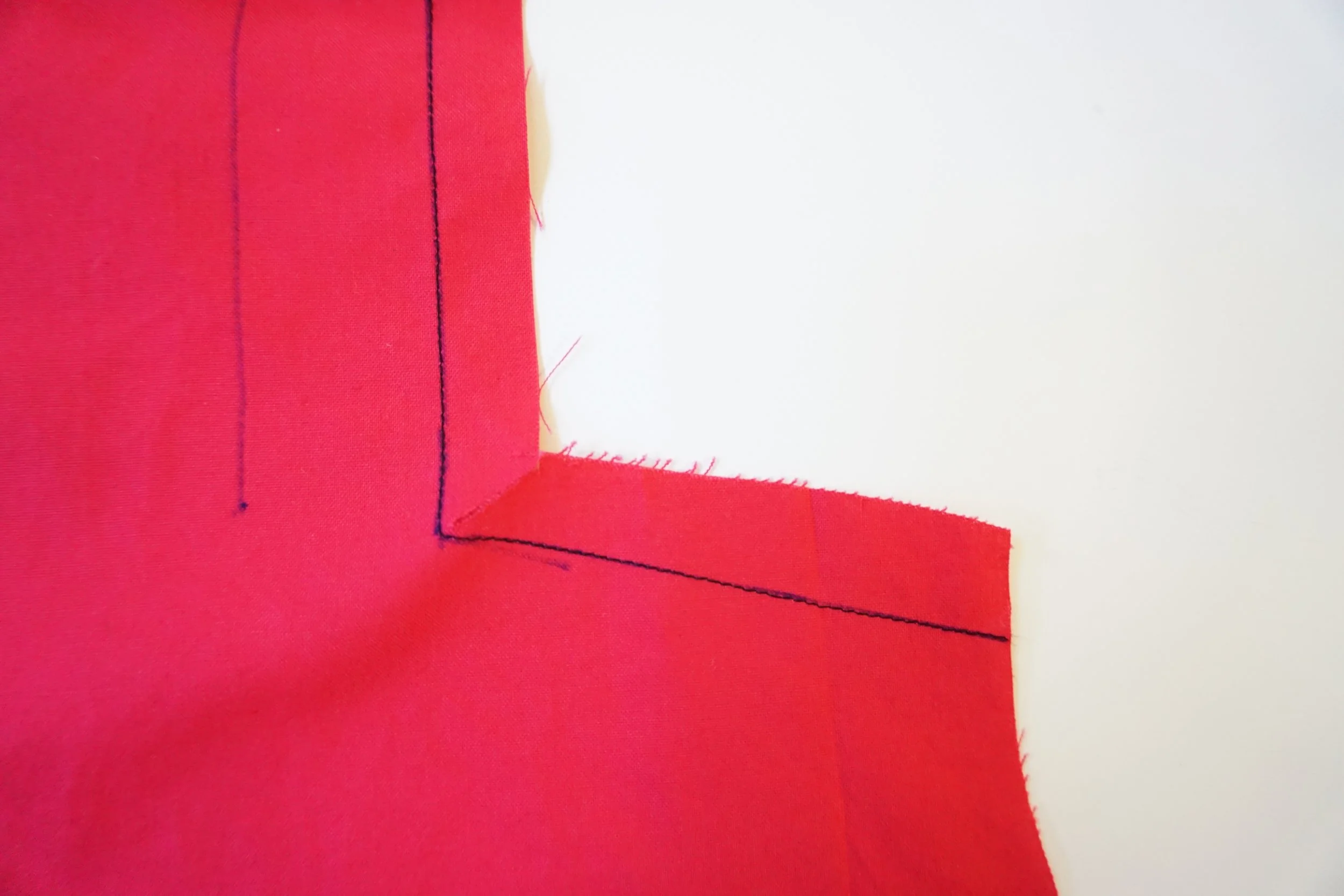 Step 1: REINFORCE the inner circle on the front bodice by stitching from the top, pivoting at the circle and continue stitching to the side. REINFORCE : stitch along seamline where indicated, using small machine stitches. (Always check the Glossary in your pattern instructions for any BOLD words you're not familiar with)