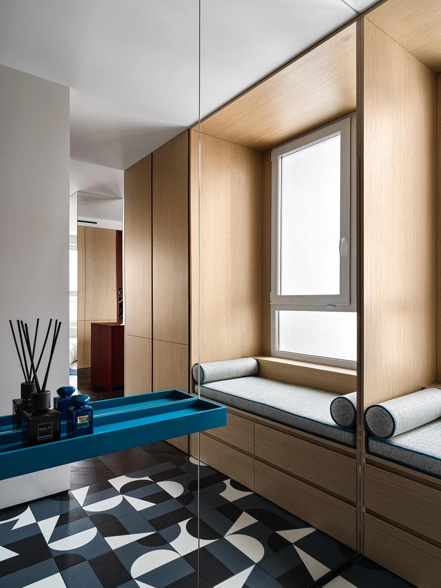 Прихожая с окном - самое необычное решение в исходной планировке, с которым приходилось работать. 

Окно делает компактную прихожую свободнее и добавляет воздуха. Чтобы еще расширить пространство мы добавили зеркало во всю стену, а окно обрамили в шп