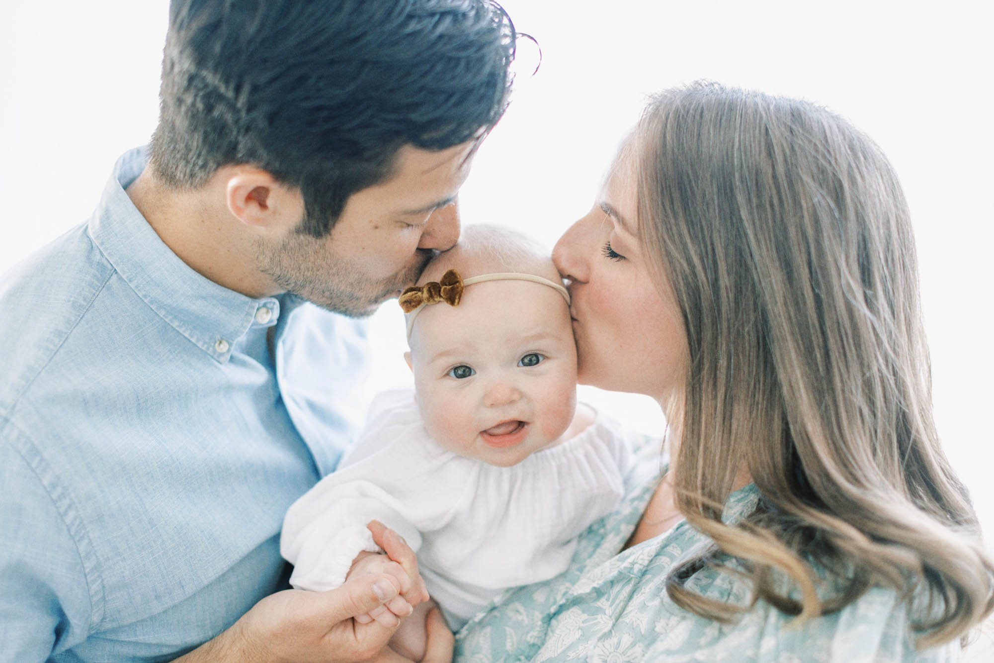 parents-kissing-6-month-old.jpg