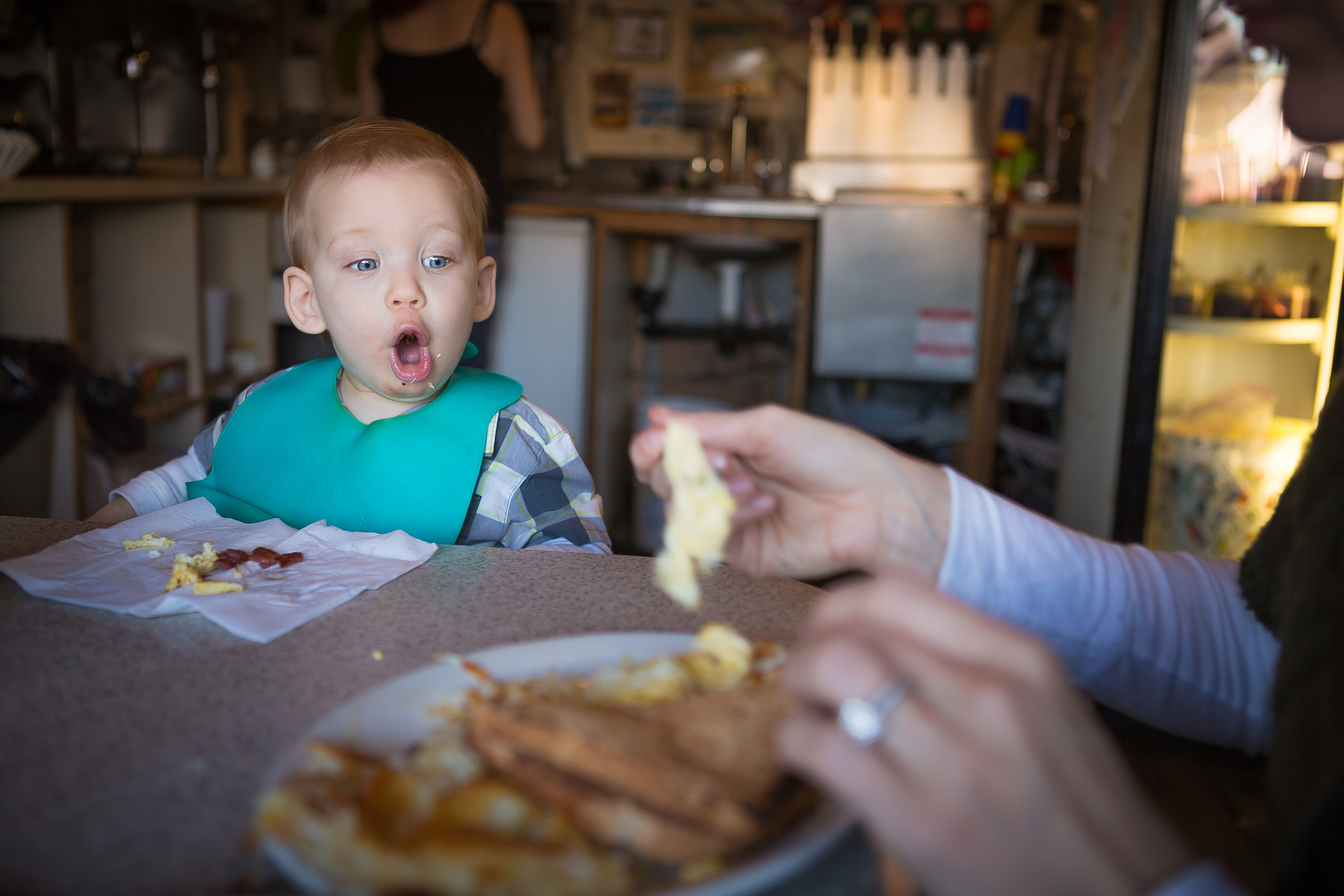 The AV was set at 2.8 for this picture of my son who wigged out when he saw the big plate of food they brought mom. If the AV had been high like a 22 then everything would be in focus and would draw attention away from the main focal point of the shock on my sons face.