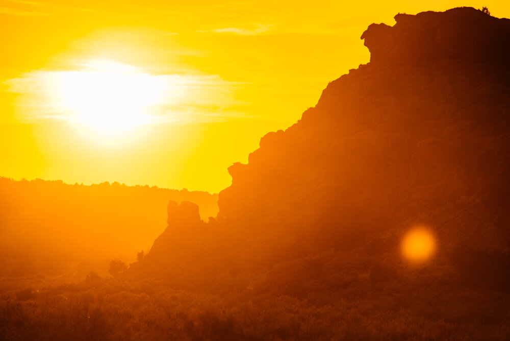 The sun sets behind a rock formation in the national monument.