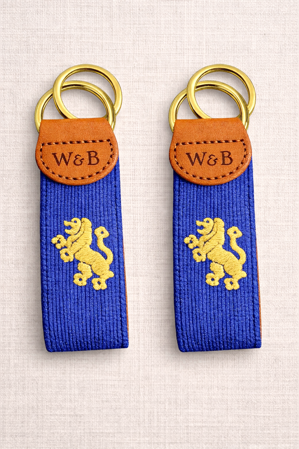 Embroidered lion key fobs on linen.png