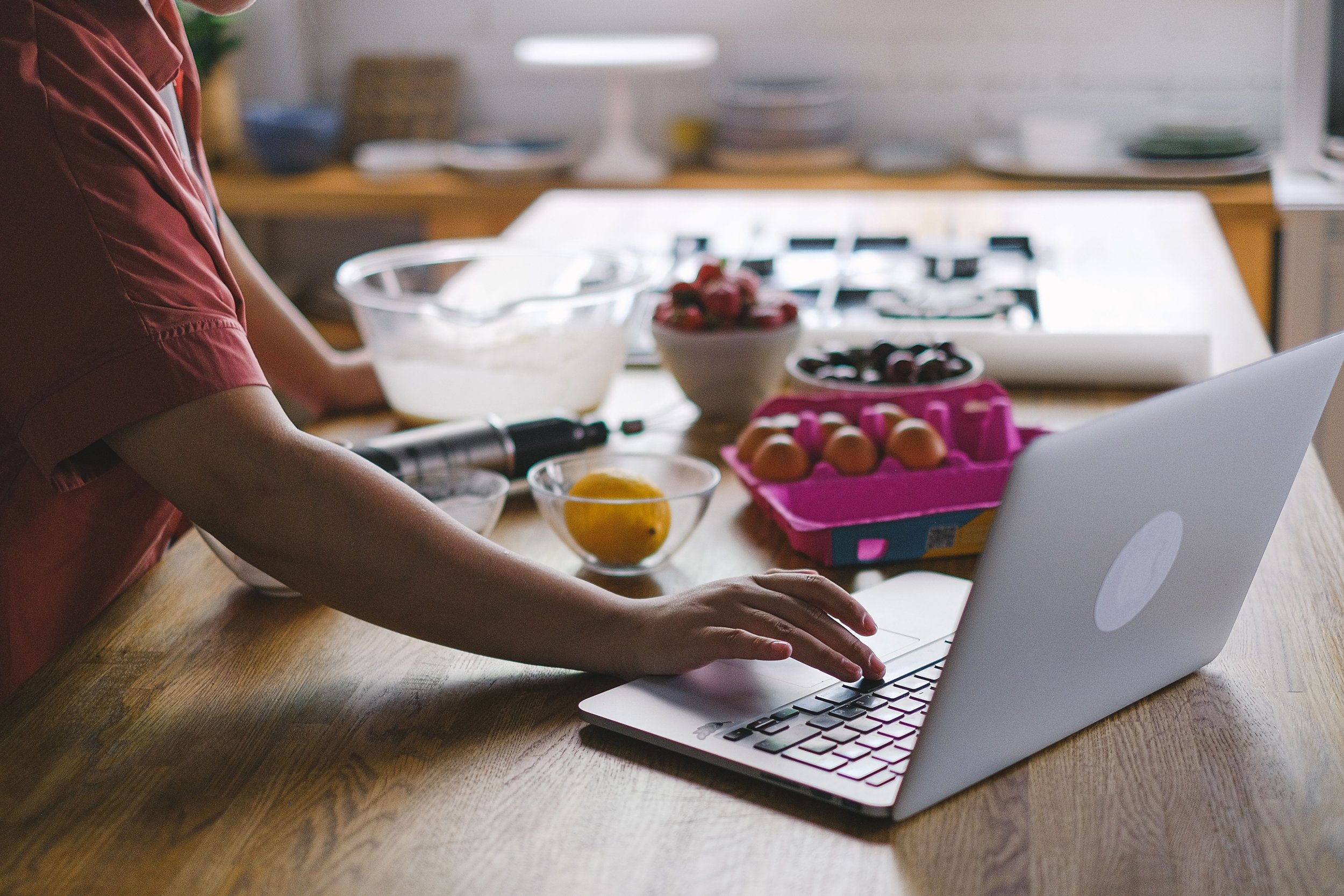 Woman in kitchen using laptop