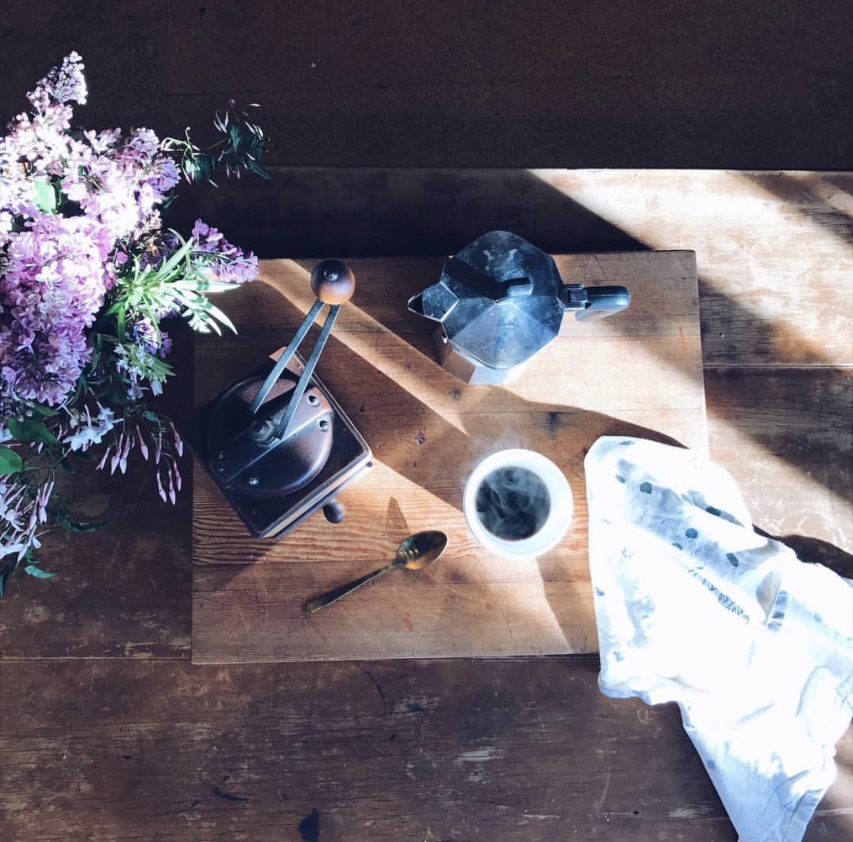 Kate captures impermanence with this beautiful morning coffee situation. The light and shadows will be fleeting, as will the steam from that cup of coffee. The time worn beauty of the table and coffee accessories is unique and can't be reproduced. The fragile nature of the flowers adds to the gentle calm of this image. By @thisfamilyrobinson