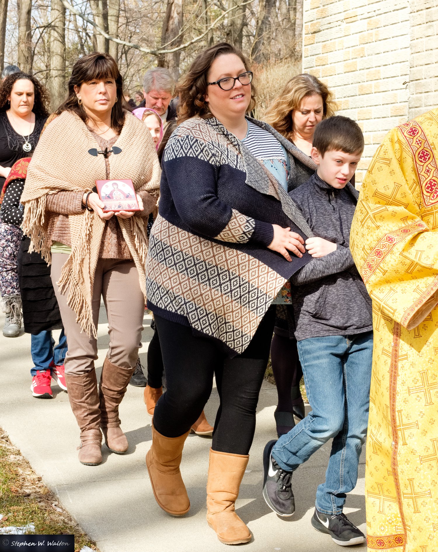  parishioners in procession outside holding icons 