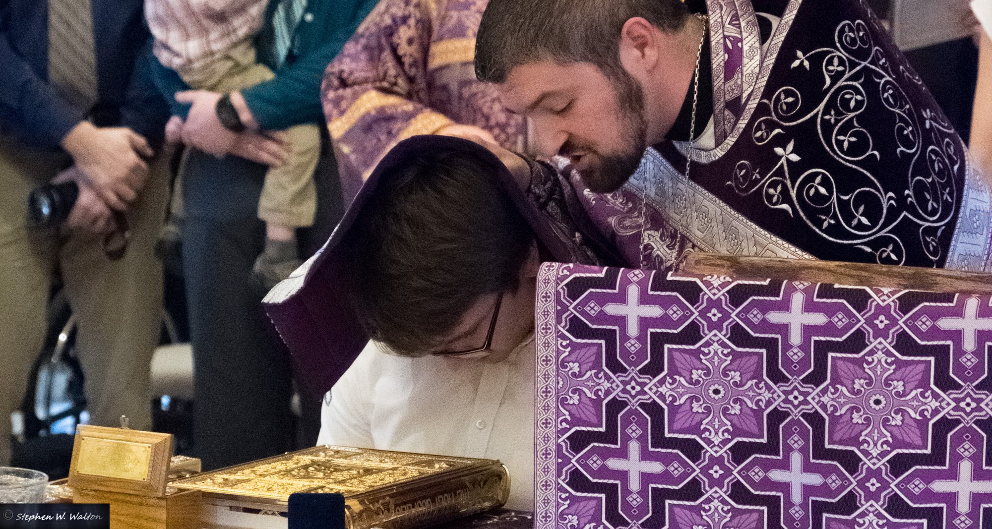  priest covering head of young male with stole offering prayers of absolution 