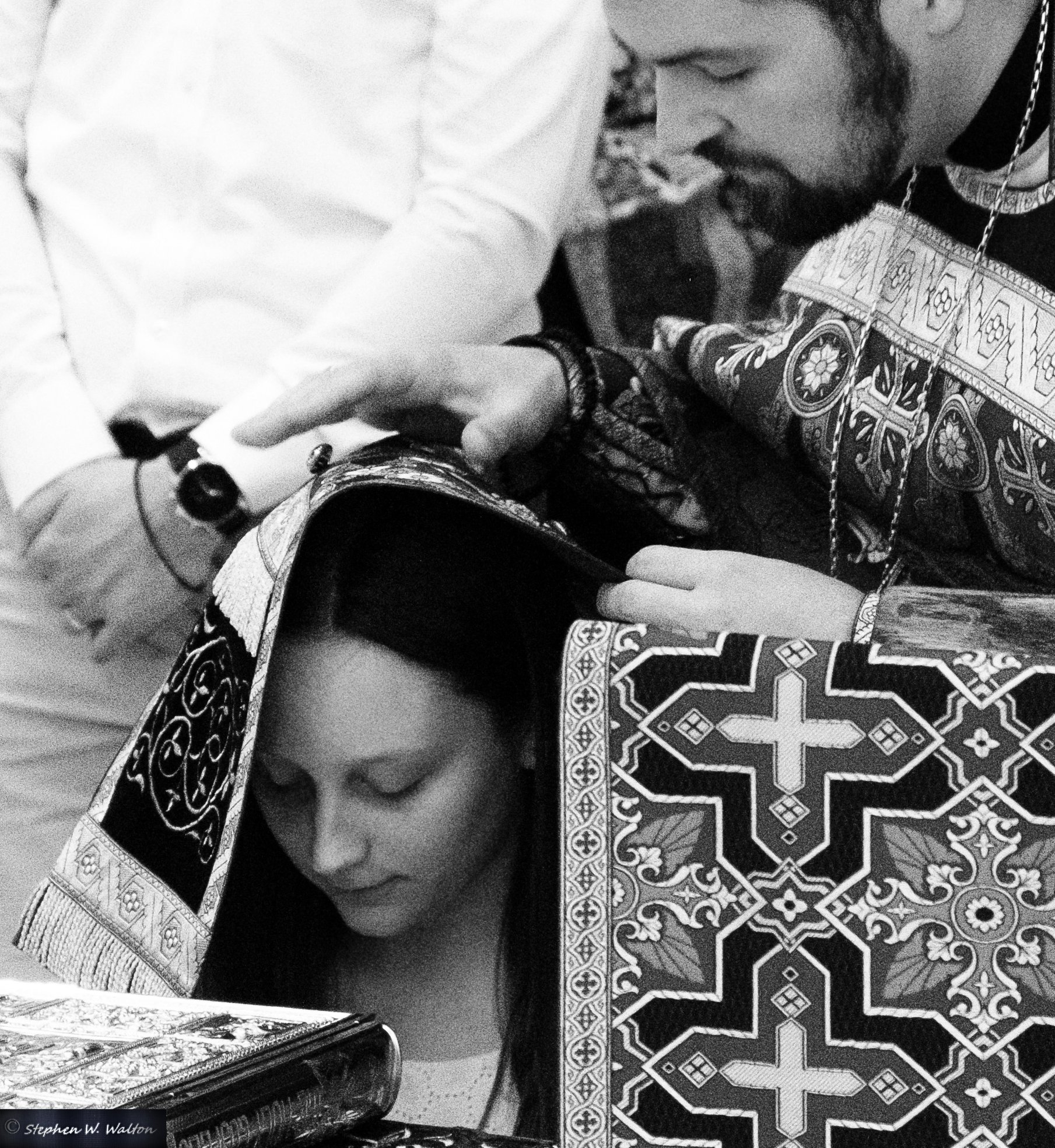  priest with stole covering head of young woman offering prayers of absolution 