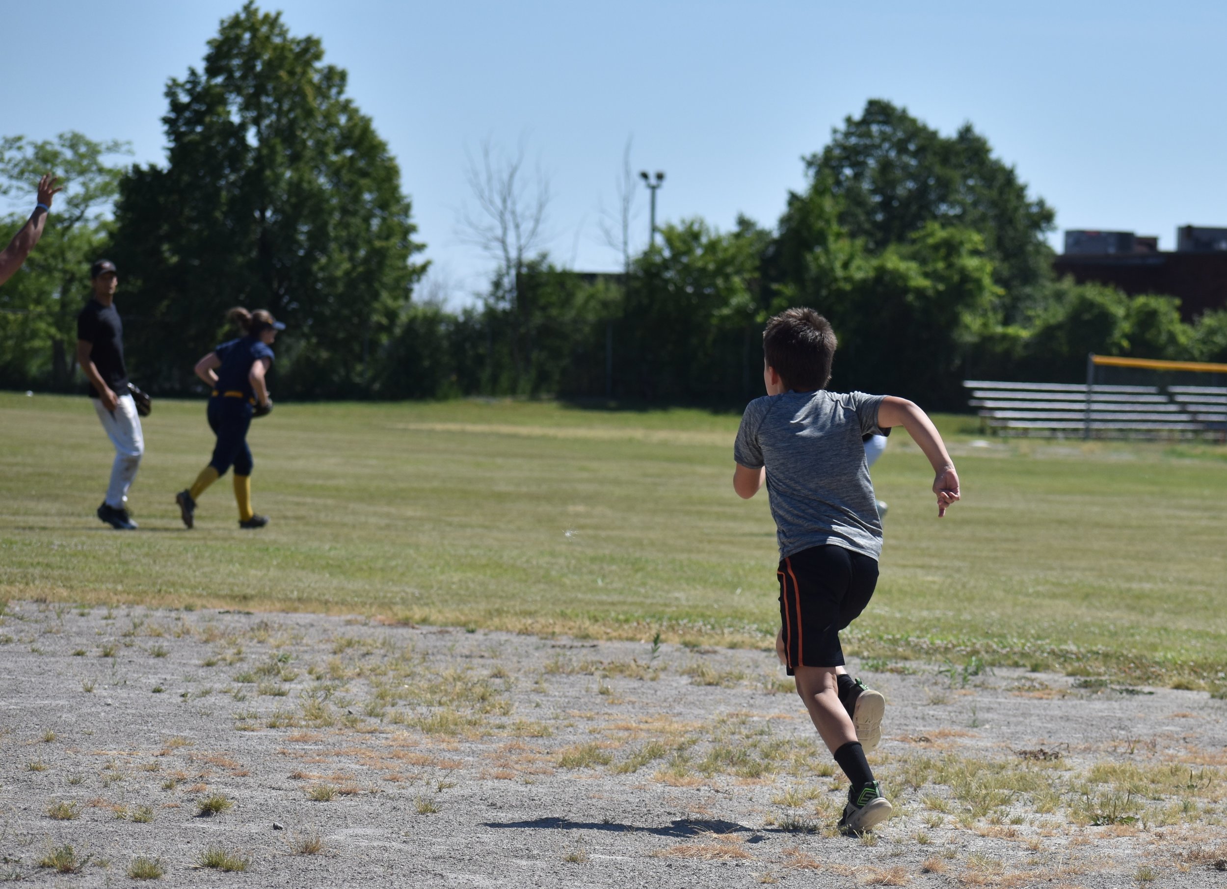 young boy running to second base