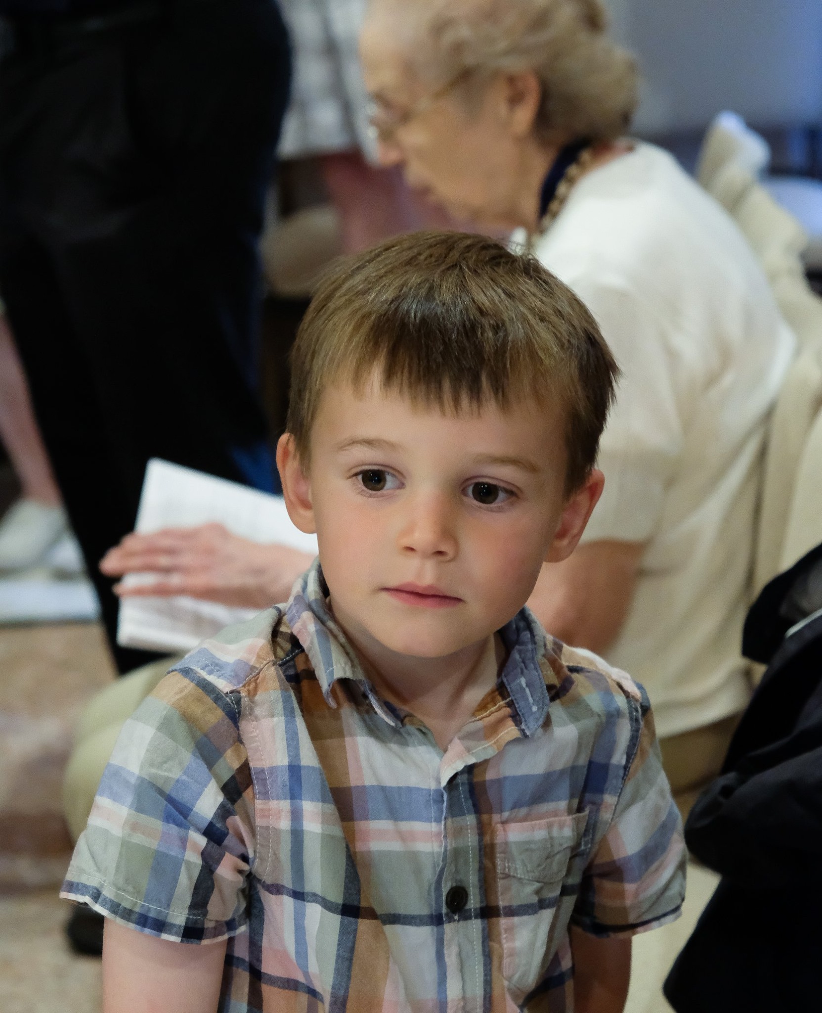 small boy in plaid shirt during service
