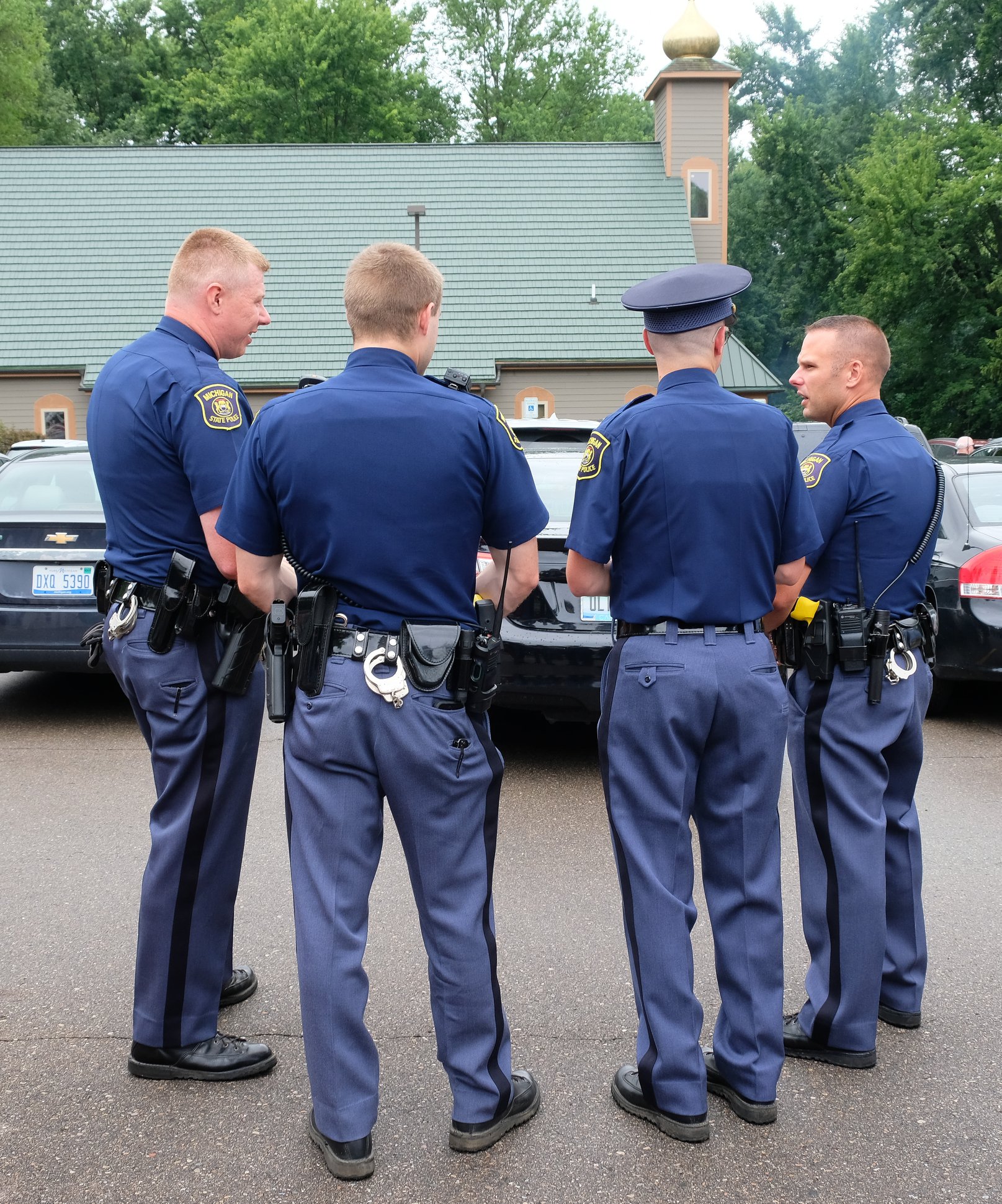  four state troopers standing together in church parking lot 