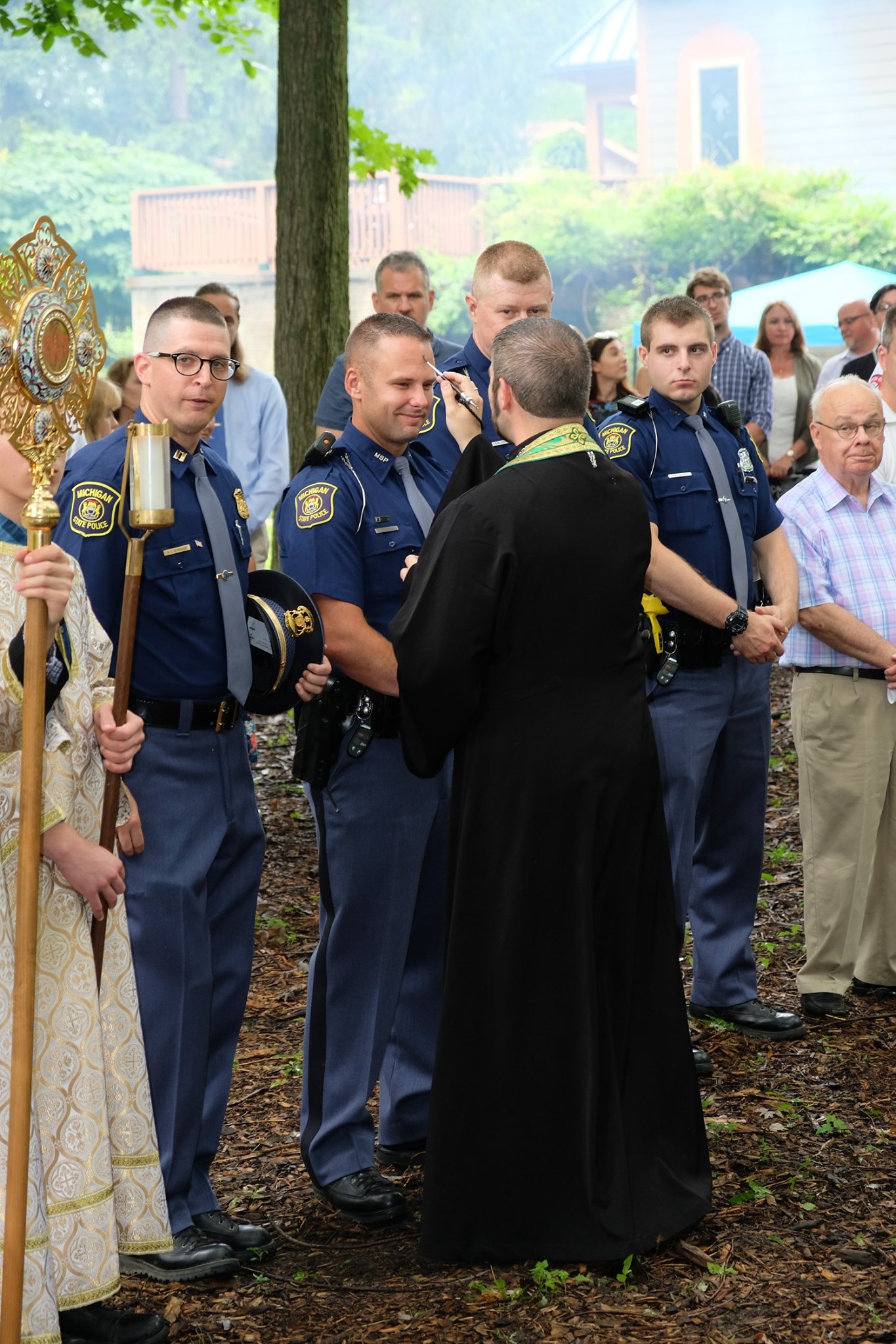  priest anointing state trooper with oil 