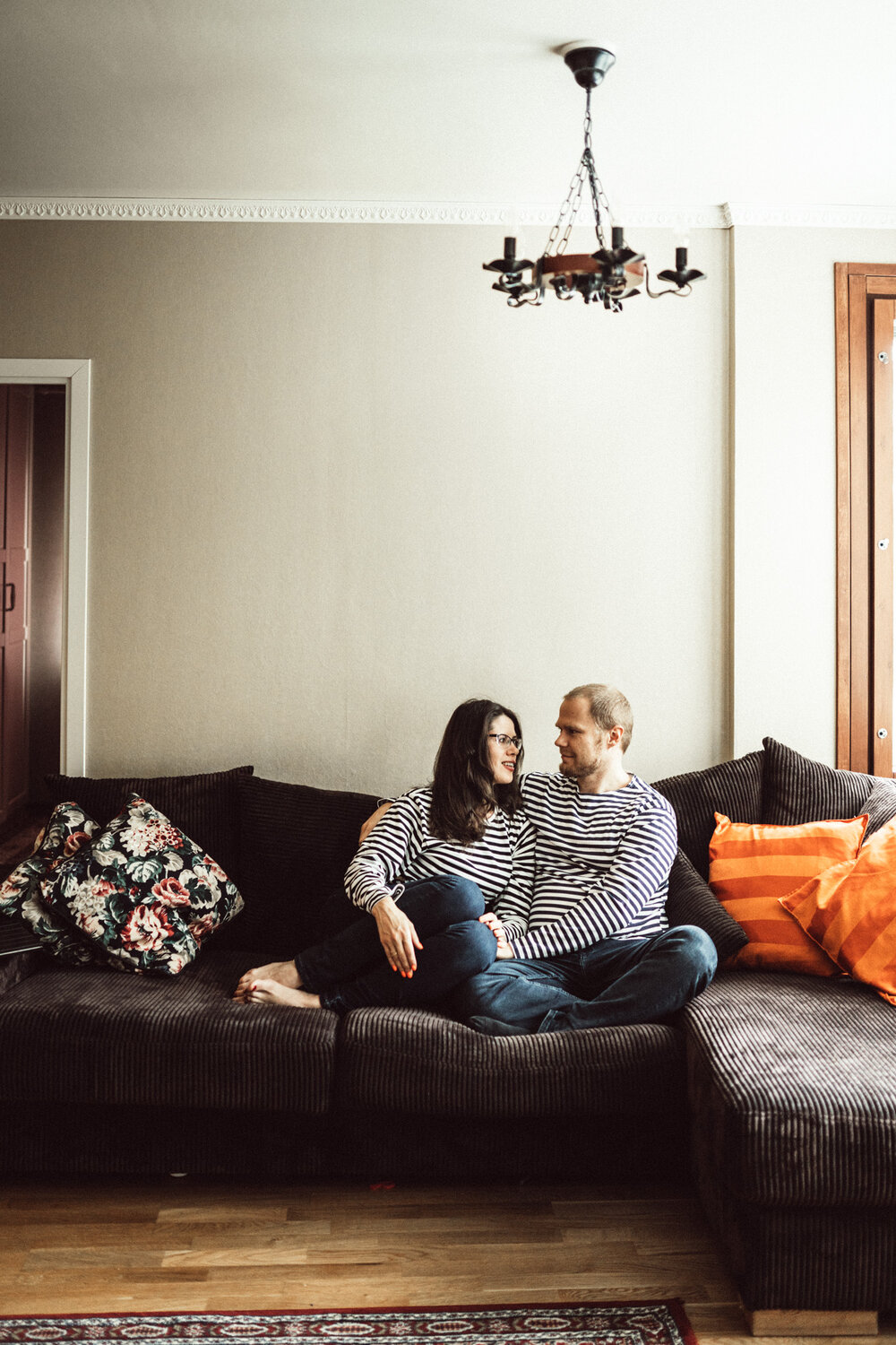 Beautiful couple sitting on sofa at in-home photo session in Kuopio, Finland (Copy)