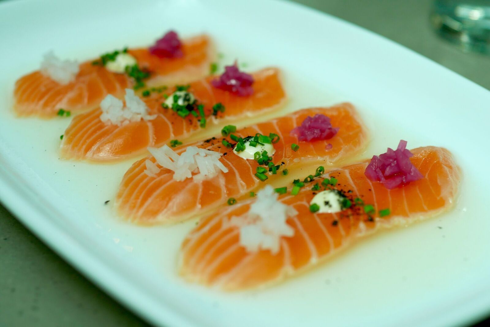 OZO STIILIS LÕHE SASHIMI 8€ Trühvliõli, valge redis, aioli, roheline sibul, must sool Kastmes võidutsev sidrunimahla maitse jättis suu huvitavalt kuivaks nagu kuiva veini puhul. Kooslus ei olnud soolane, pigem üsnagi trühvlimaiguline, mis meile väga meeldis. Lõhe oli kenasti värske ja kõik need pisikesed lisandid täiendasid teineteist. Soovitame!