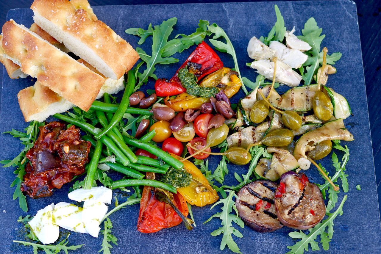 VÄRVILINE KÖÖGIVILJAVALIK 12€ Arstišokisüdamed, oliivid, röstitud paprika, marineeritud baklažaan ja suvikõrvits, kapparid, värske basiilikupesto, buffalo mozzarella, aedoad mündi ja küüslauguga, kirsstomatid, Caponata salat, rukola Tervislik ja värviline snäkivalik, mida Tallinnas suhteliselt harva kohtab (tavaliselt heal juhul ainult juust ja sink valikus). Meie lemmikuteks olid artišokisüdamed, marineeritud baklažaan ning suvikõrvits, mis oli kaetud mõnusa tomatise kastmega. Tõeliselt kerge ja suvine roog, mis ei pane ka oma vööümbermõõdu pärast muretsema. Kui sina oledki see sarisnäkkar, kes pidevalt midagi mäluda tahab, siis isutekitajaks on see parim valik! Haara vein või mõni muu meelepärane jook ja mine naudi seda oma sõbra(nna)ga armsal lilledega kaetud terassil. Soovitame!