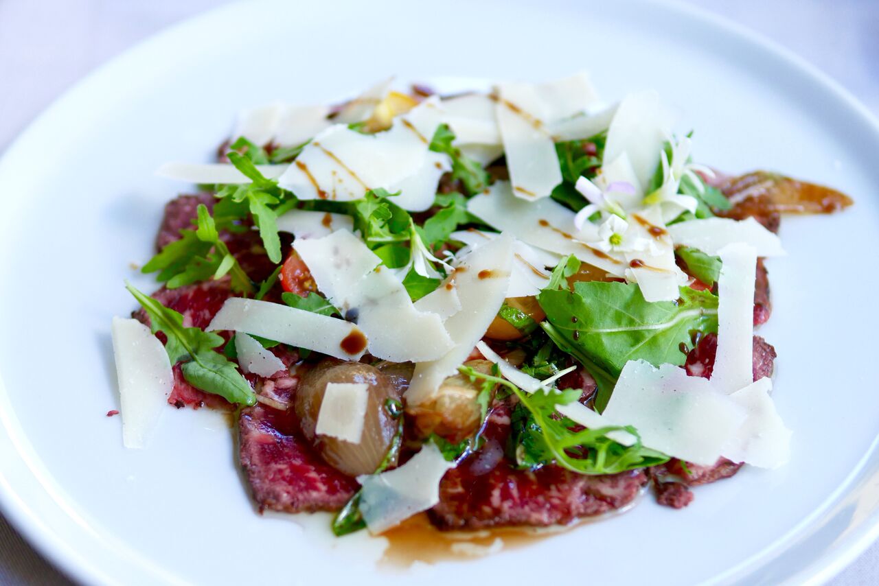 VEISELIHA CARPACCIO 11€ Rucola, pähklid, tomatisalsa, sibul, parmigiano juust Veiseliha carpaccio on miski, mida kohtab pea igas restoranis ja üsna samasugusel kujul. Siin aga selgus peakokaga vesteldes, et liha on just spetsiaalselt tavalisest paksemaks jäetud, et tuua rohkem esile selle maitset. Ja see magus karamelline sibul oli ikka tõeline primadonna, tegemist on tõesti oskuslikult valitud lisandiga - meeletult hea. Meile selline alternatiivne carpaccio väga meeldis, liha maitse tuli paremini esile kui klassikalise, eriti õhukese carpaccio puhul, kus vaat, et neelad tüki liha alla enne, kui maitset tunned. SOOVITAME!
