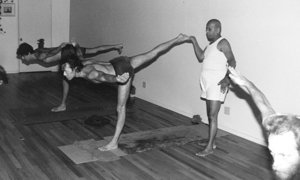 Pattabhi Jois adjust students during practice.