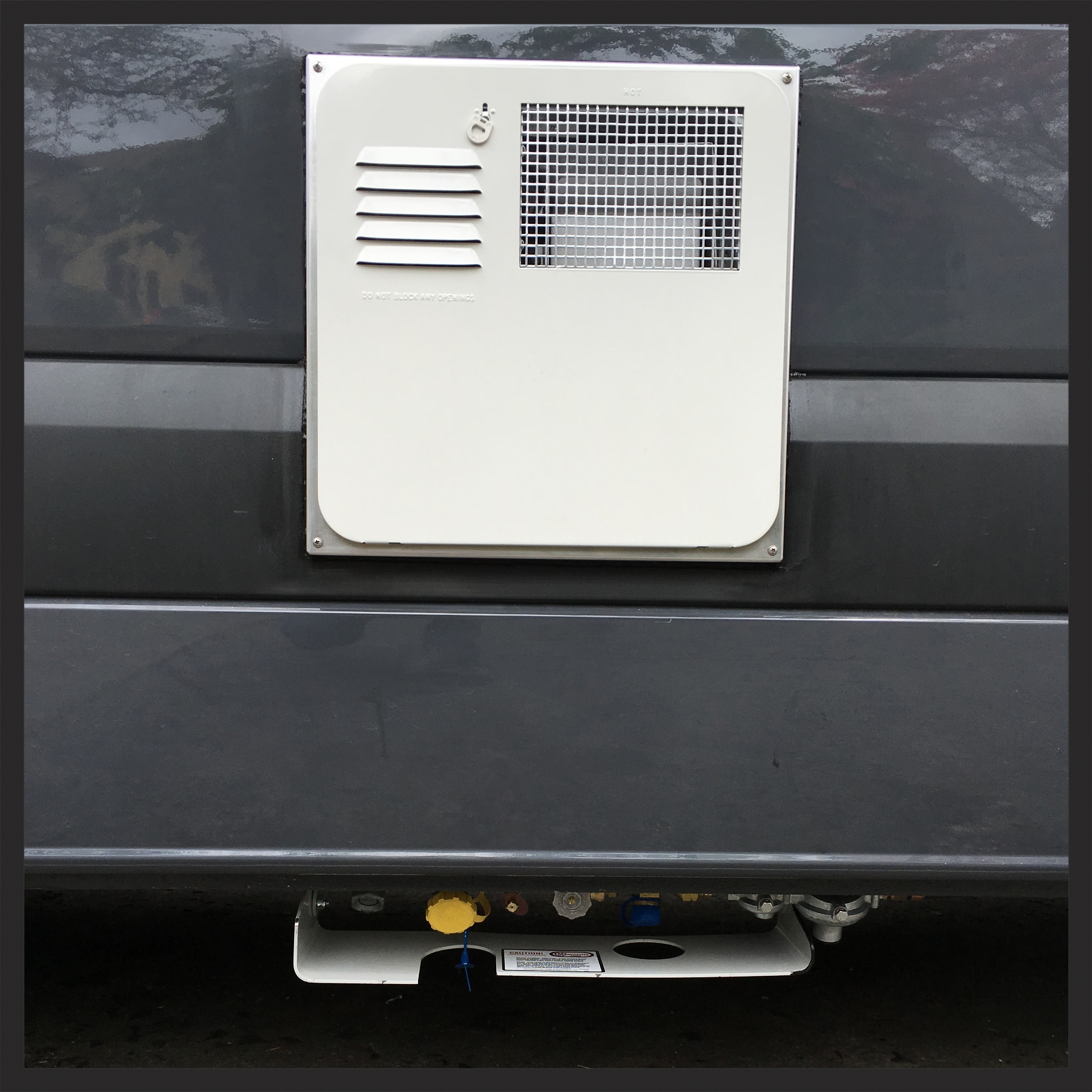 The propane inlet and hot water and hot water heater grill