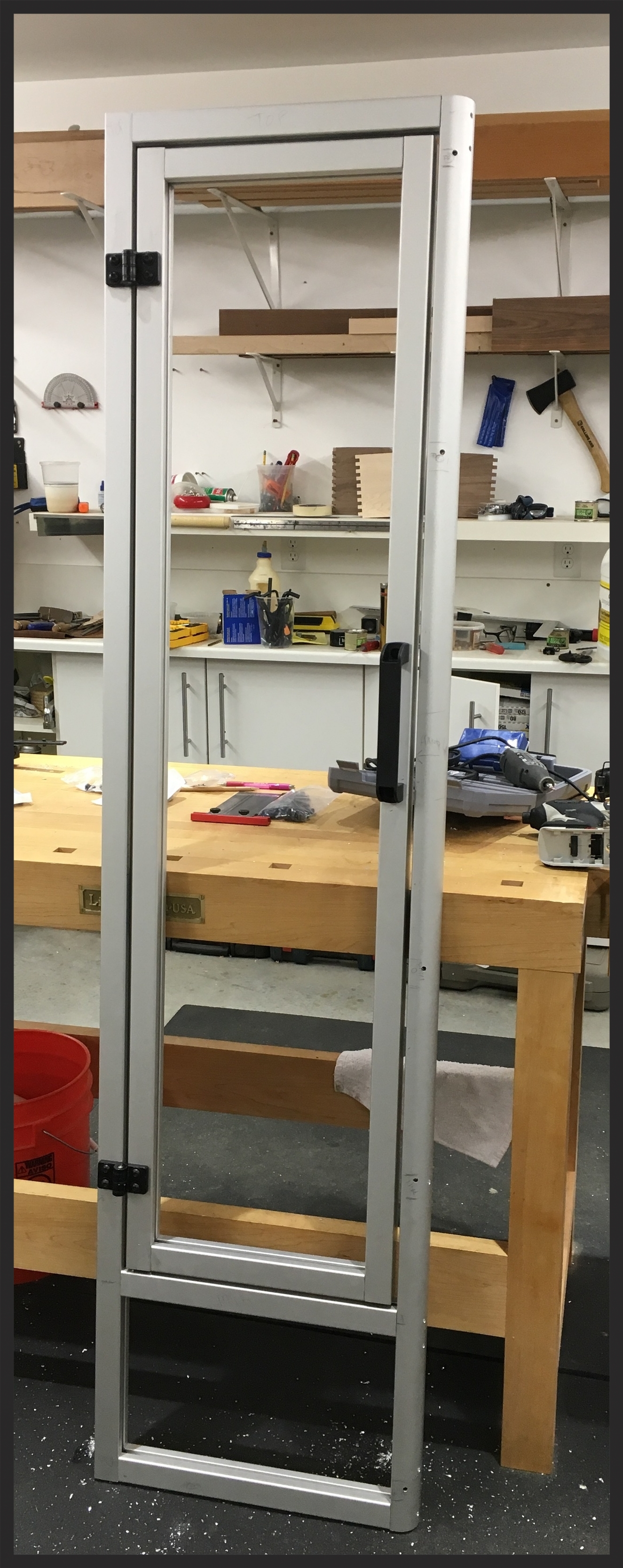The Door panel was a made of U-profile 8020 bar stock so it can take a bamboo panel inside. The panel was 3/4" ply with a rabbit cut on all four sides so it will fit into the track t-slot. The hinges are metal 8020. They are designed to go into track receivers, but I'm mounting them straight to the face frames here, so I just drilled and then tapped screw holes to mont the hinge directly. The gap between the door and the jamb will be fit with a rubber flange to make the door (hopefully) water tight. The back of the door and theshold panel will be entirely encased in fiberglass to make it water tight.