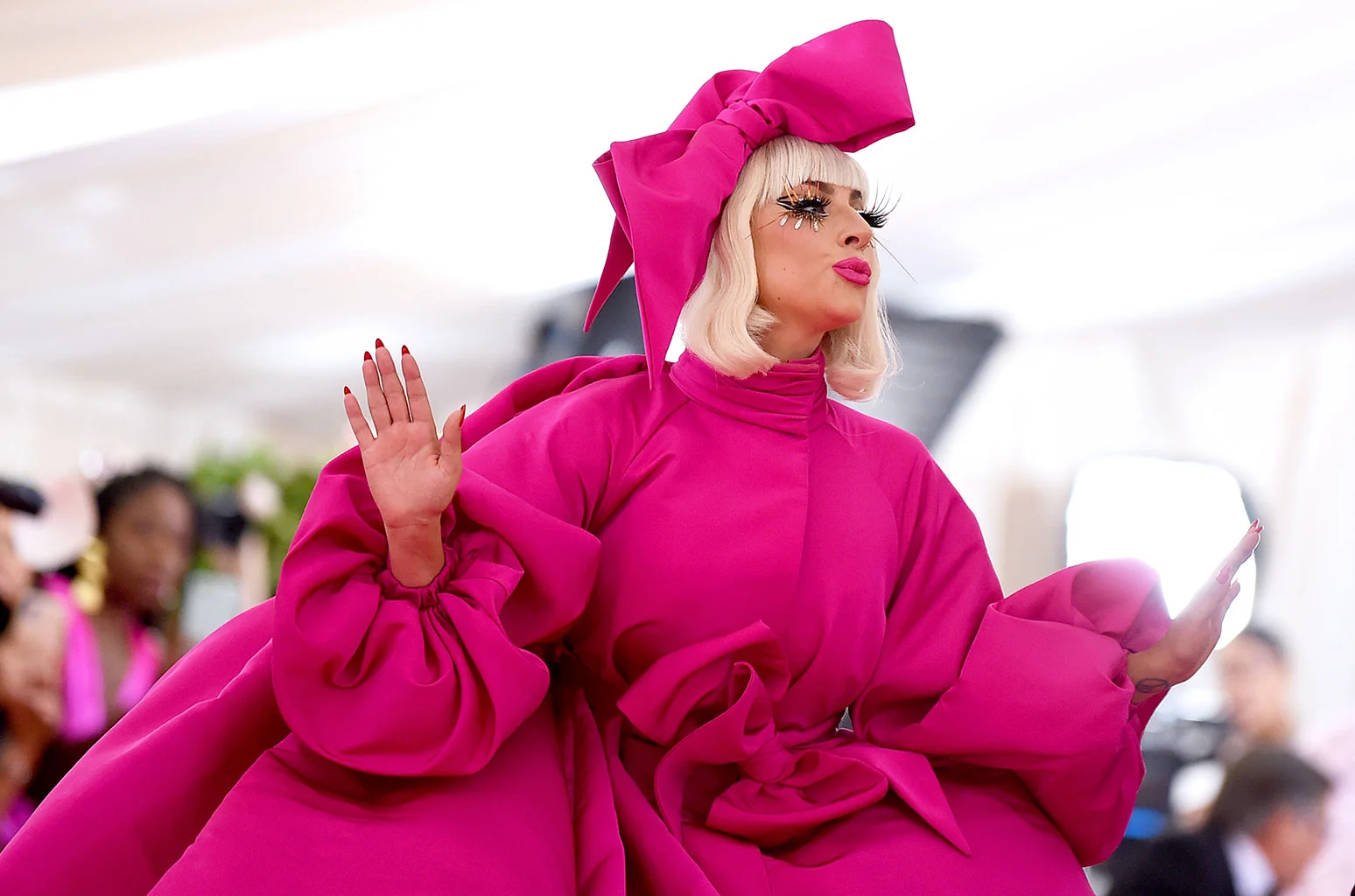 One of the four looks that the multi-hyphenate sported, accompanied by multiple handlers with umbrellas.